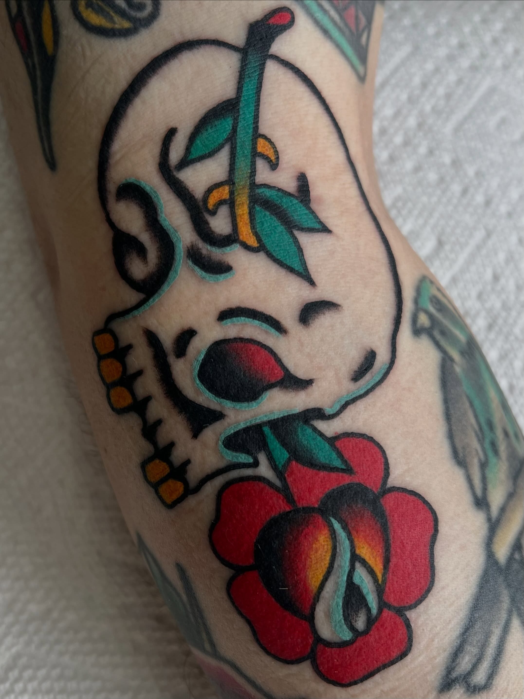 Skull with roses American traditional tattoo on the forearm by Brandon McDaniel Iowa Tattoo Artist