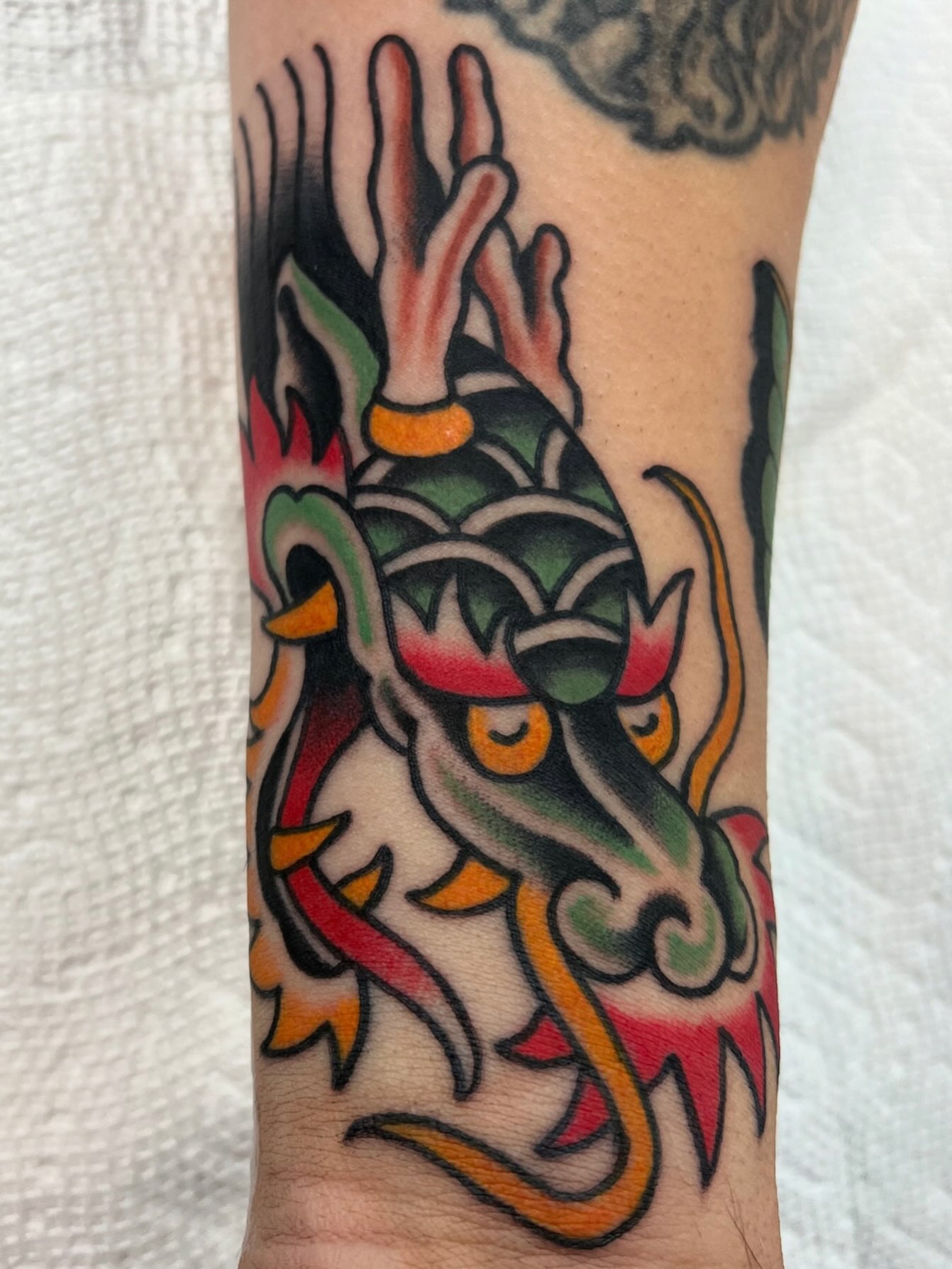 Dragon head American traditional tattoo on the forearm by Brandon McDaniel Iowa Tattoo Artist