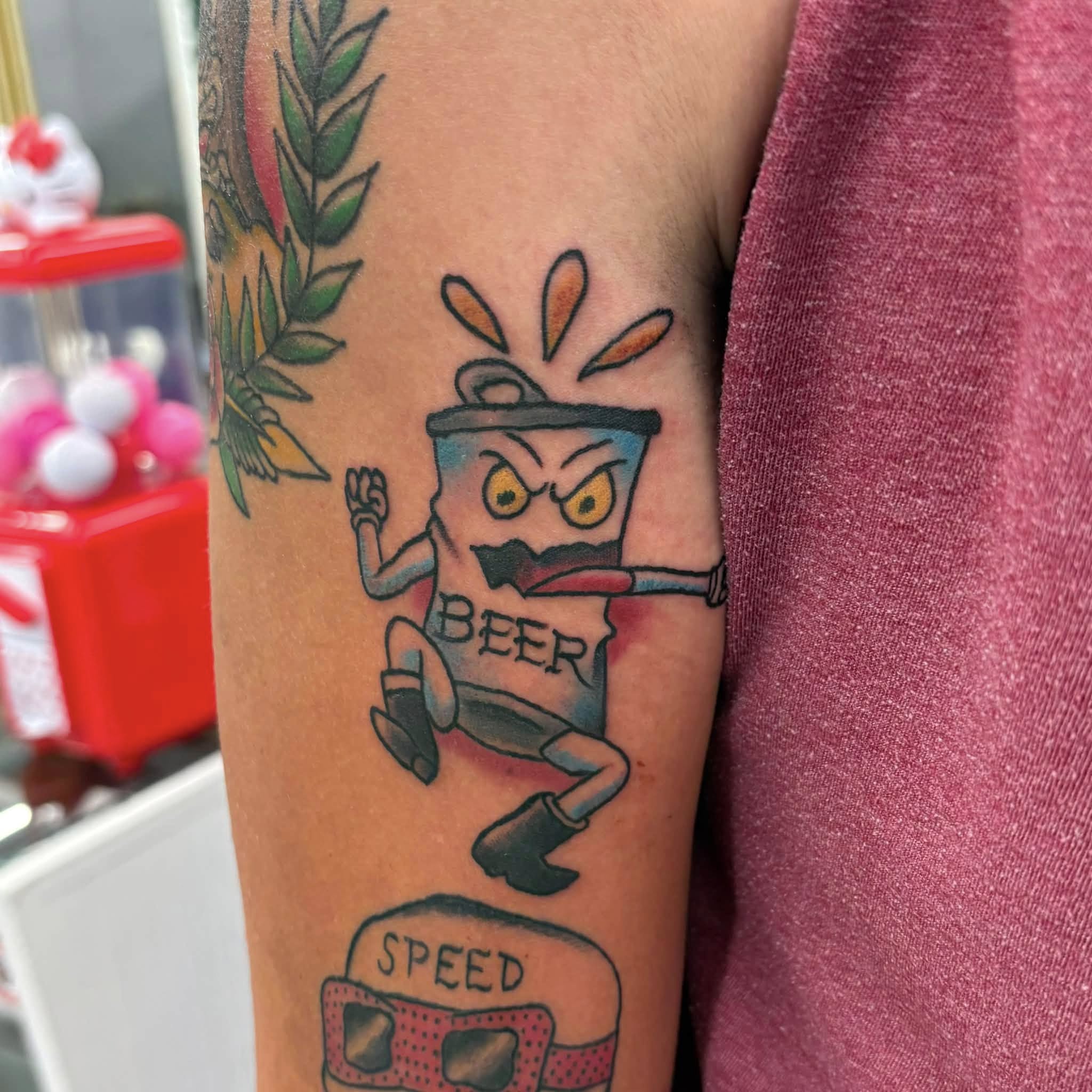 Angry beer bottle character American traditional tattoo on the forearm by Jon Anderson