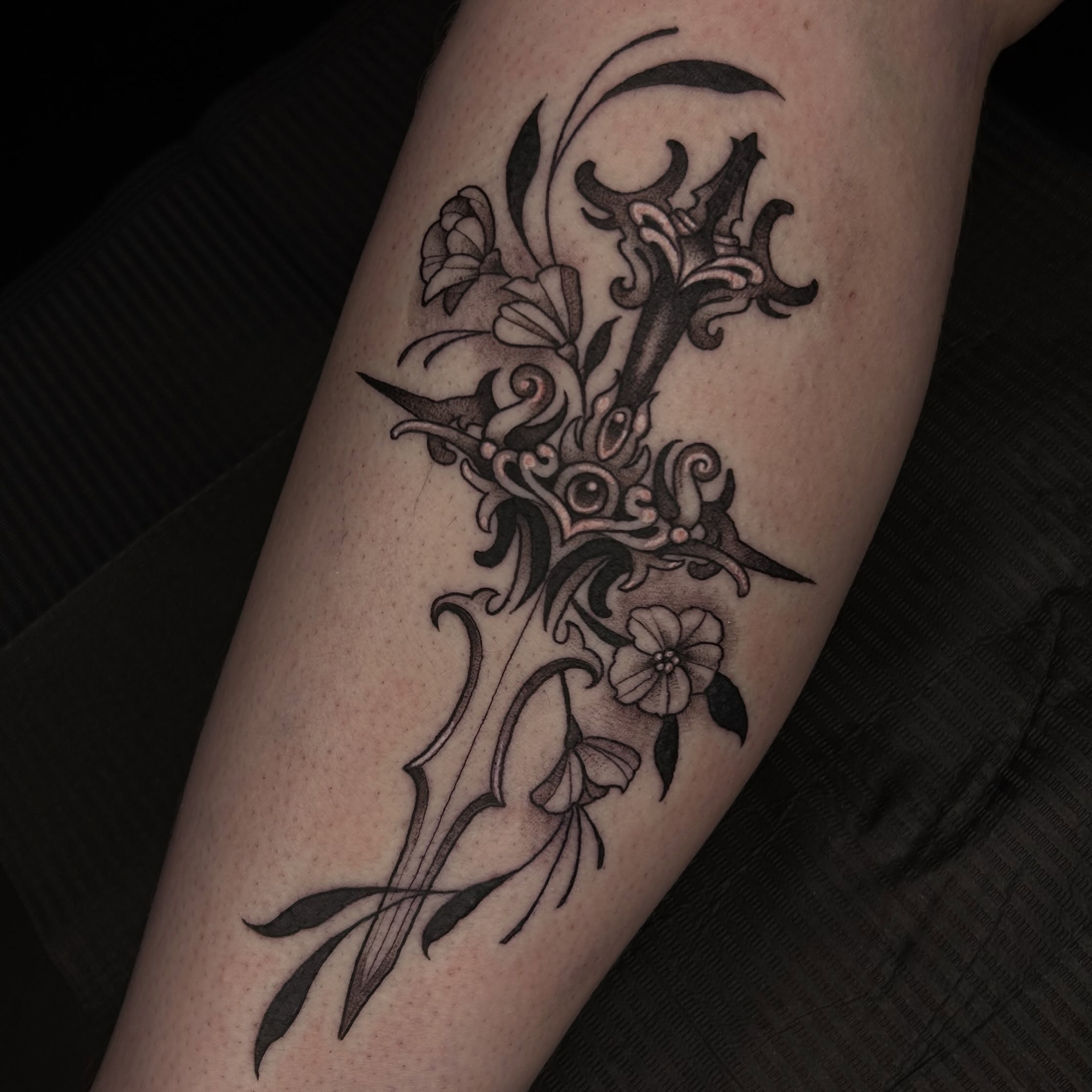 Floral sword ornamental tattoo on the forearm by Whitney Harbin