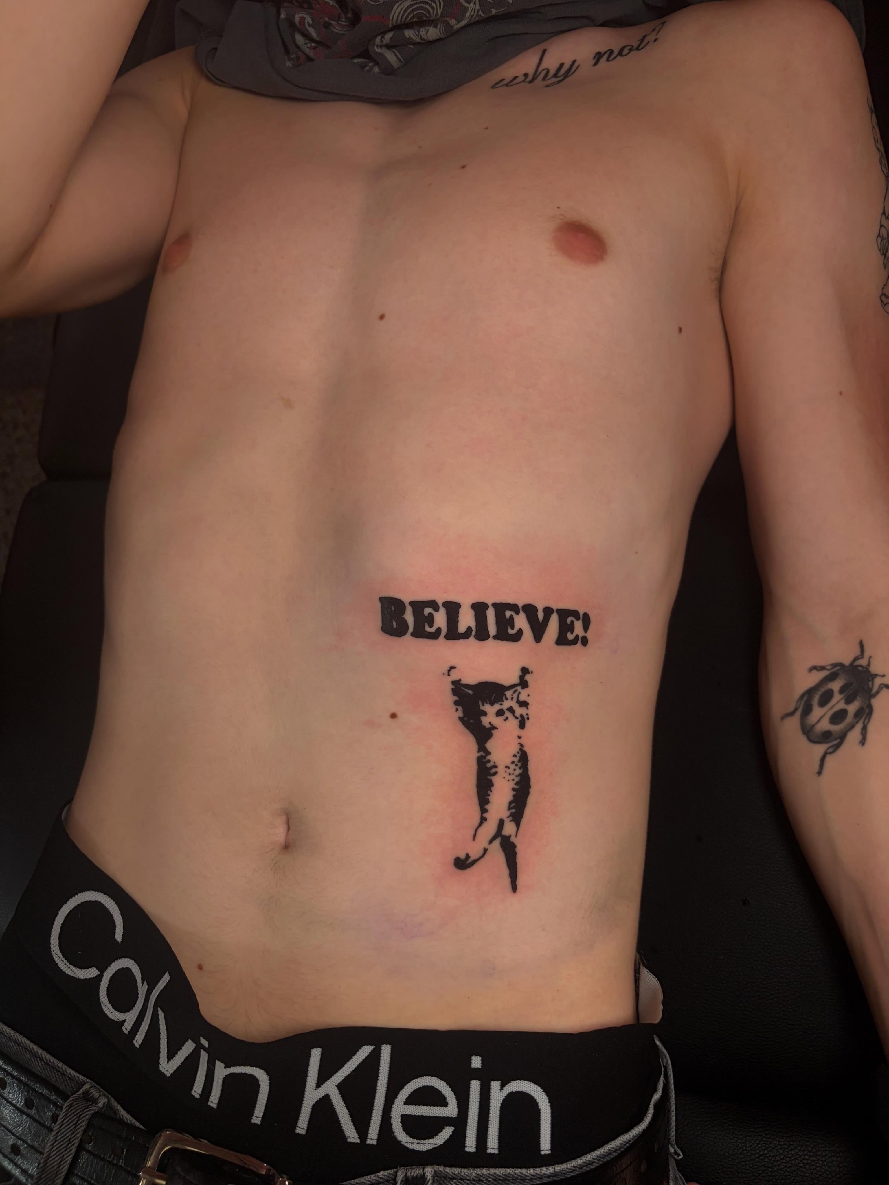 Cat black and grey tattoo on the torso by neal
