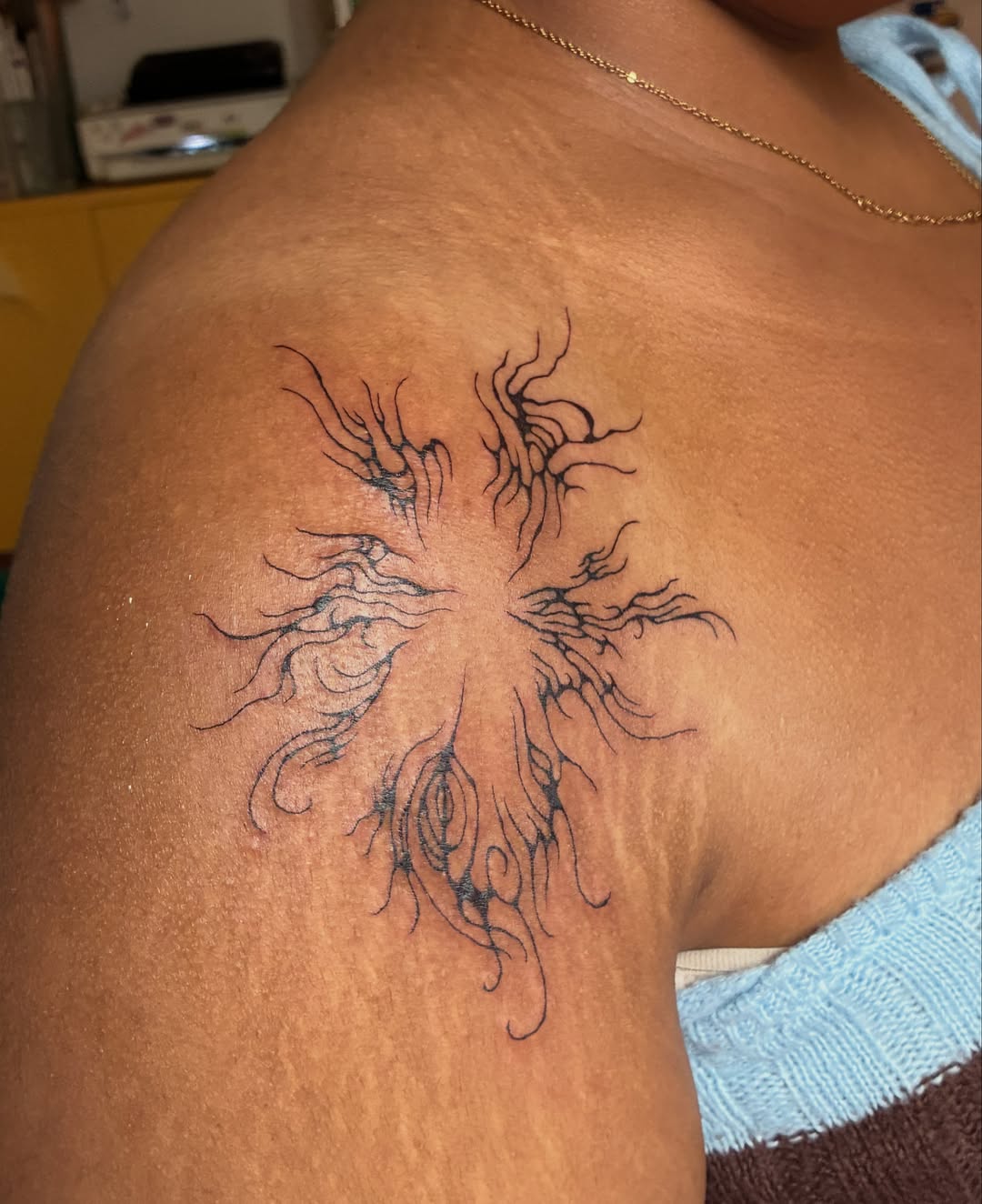 Cross with organic swirls black and grey tattoo on the shoulder by thalia