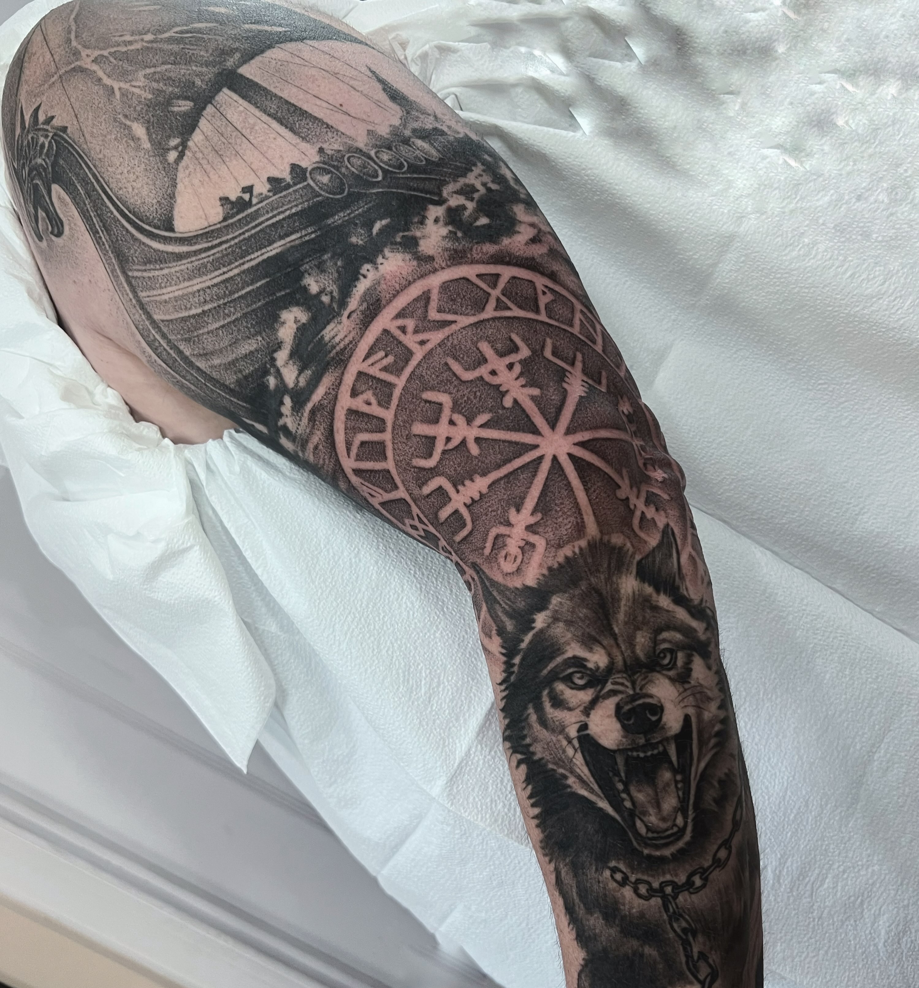 Wolf and viking ship realism tattoo on the forearm by Anna Wolff, Richmond, Virginia