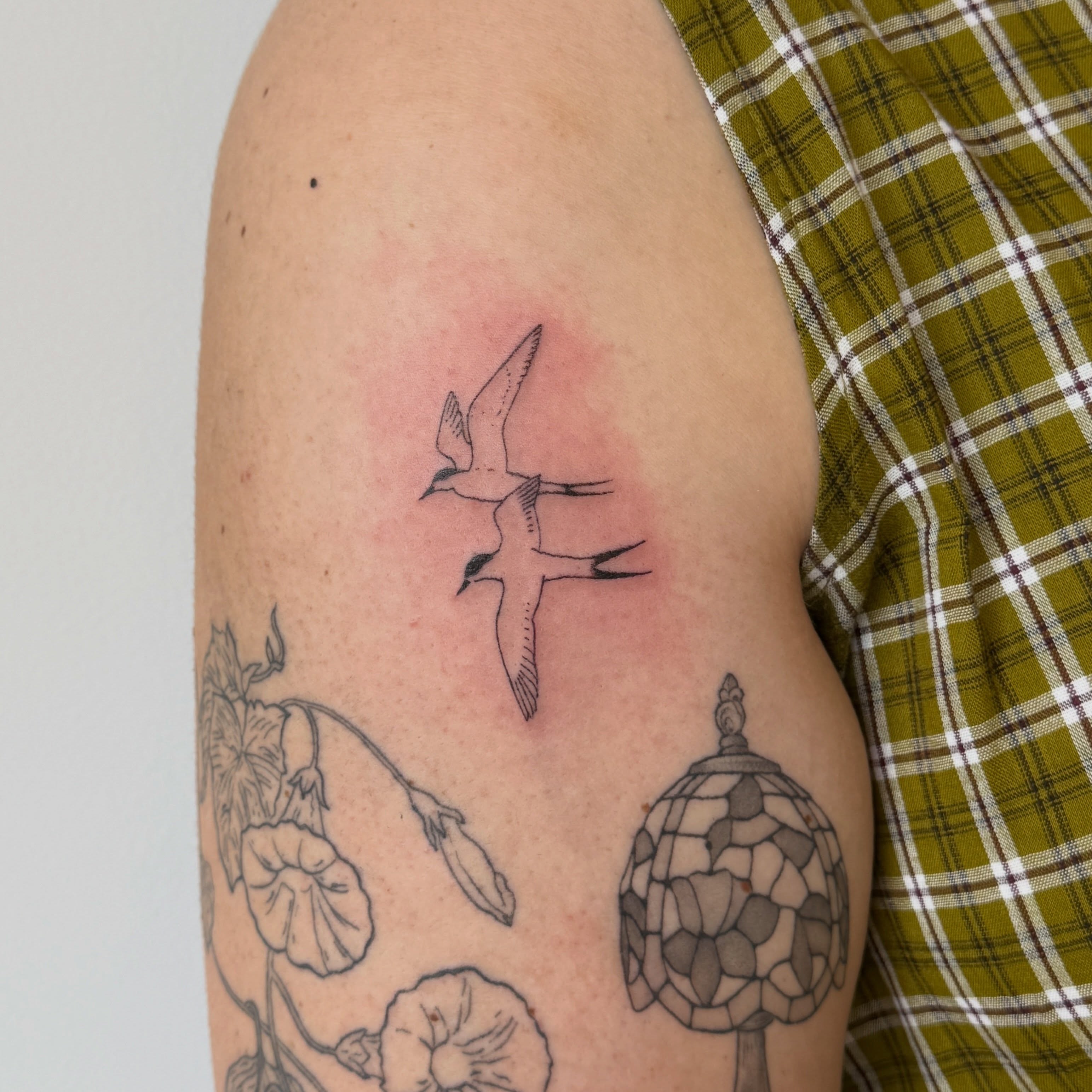 Seagulls black and grey tattoo on the upper arm by Kirsten