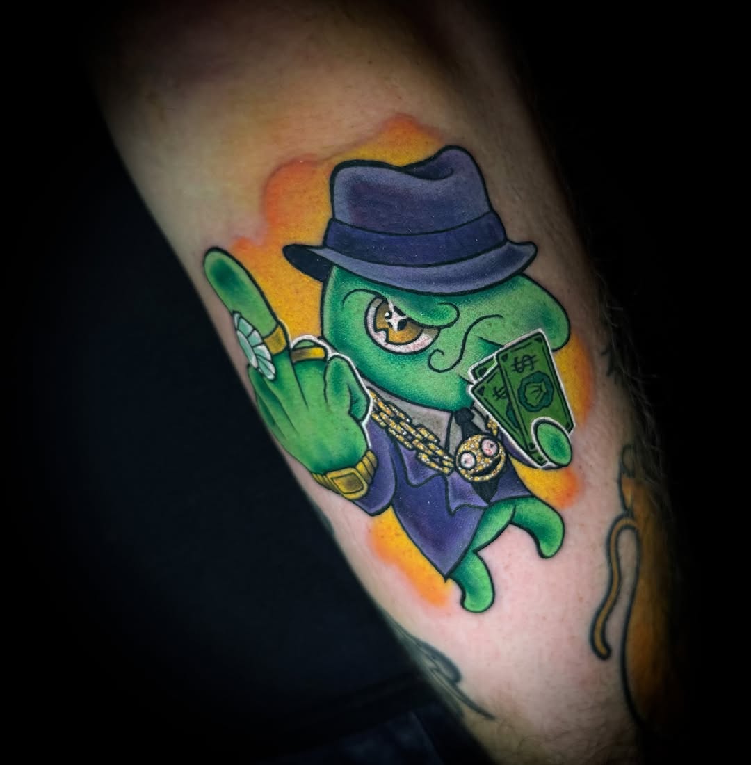 Frog wearing hat new school tattoo on the forearm by Savannah Duff