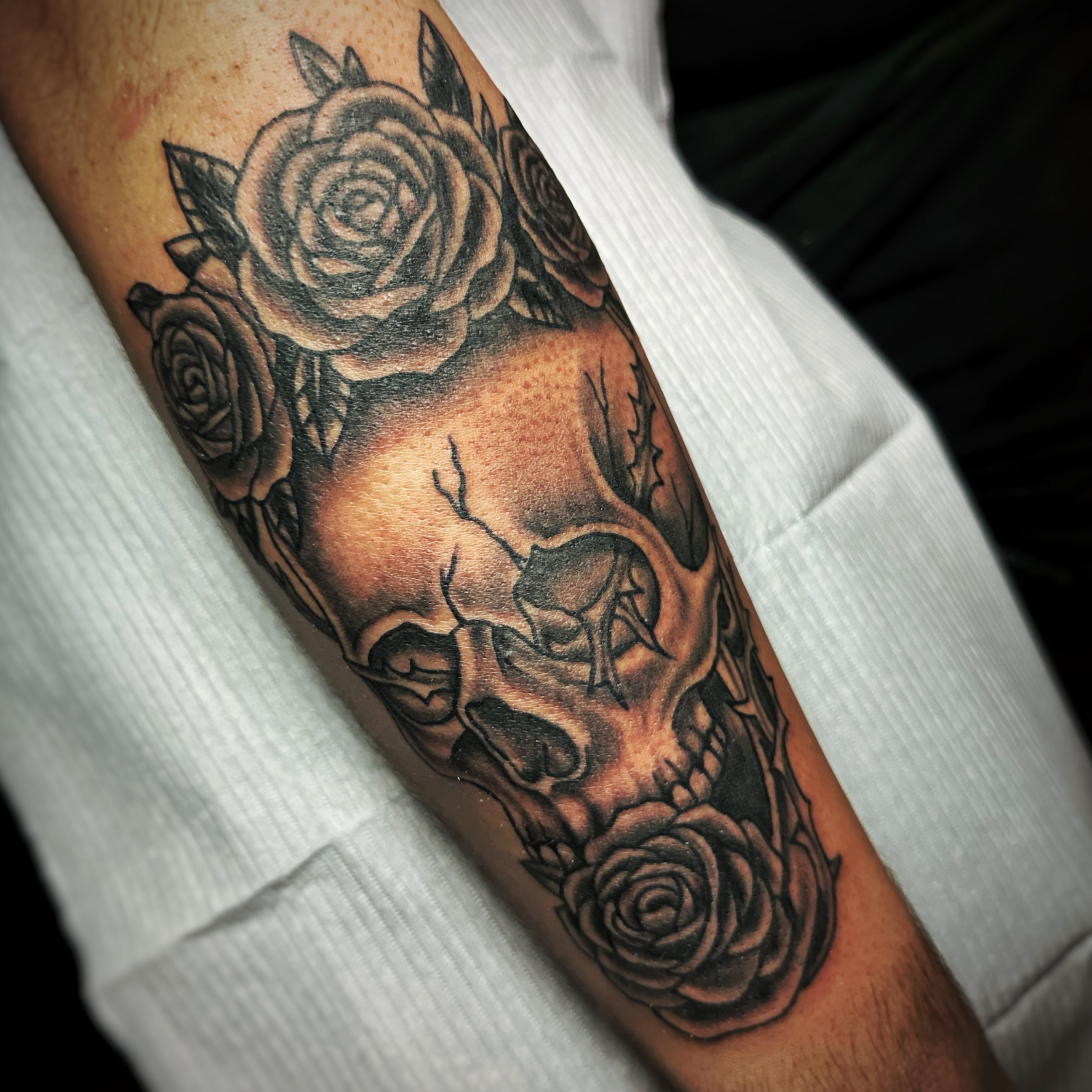 Skull and roses realism tattoo on the forearm by Anthony Guido
