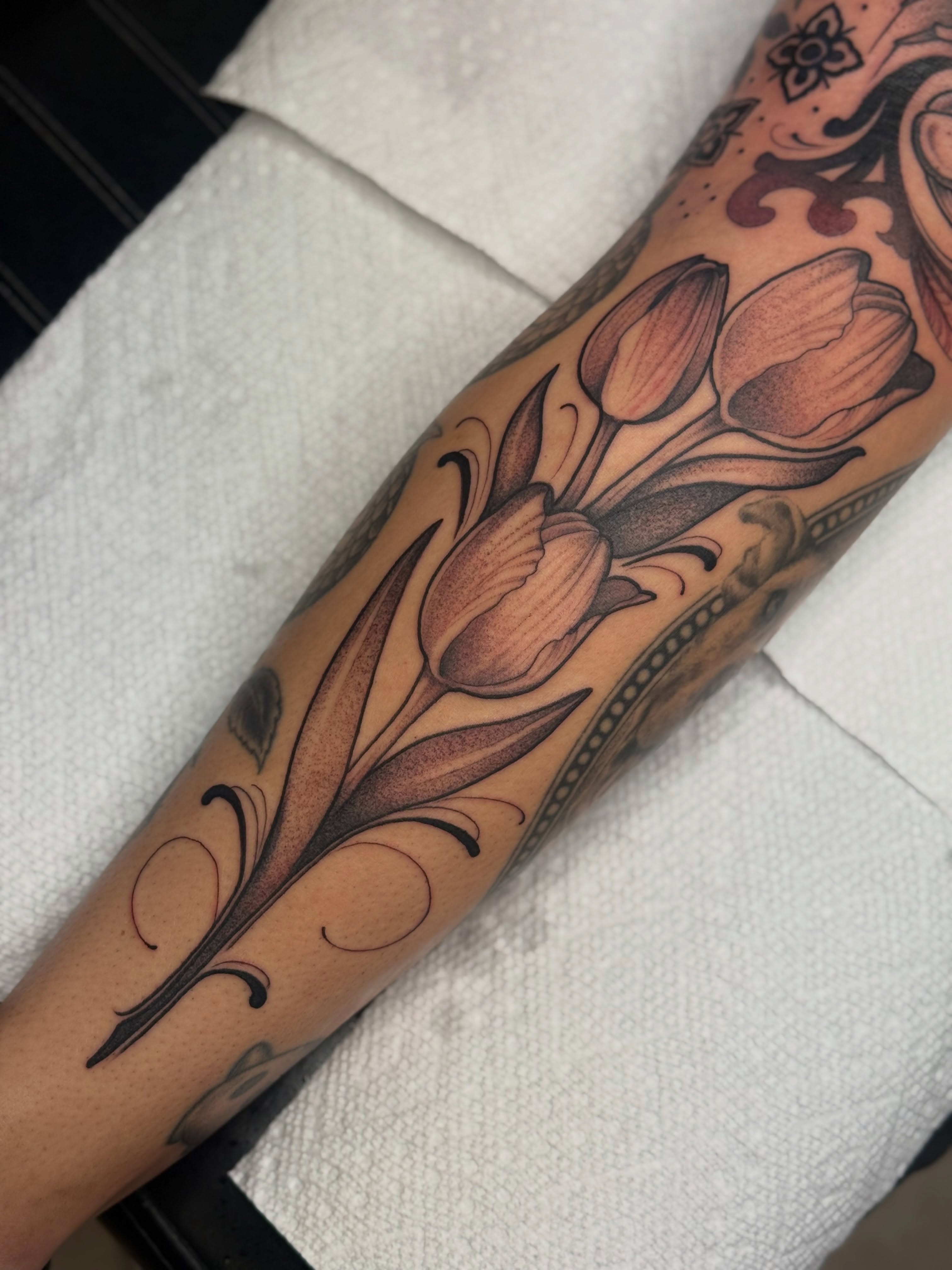 Tulips black and grey tattoo on the forearm by K9