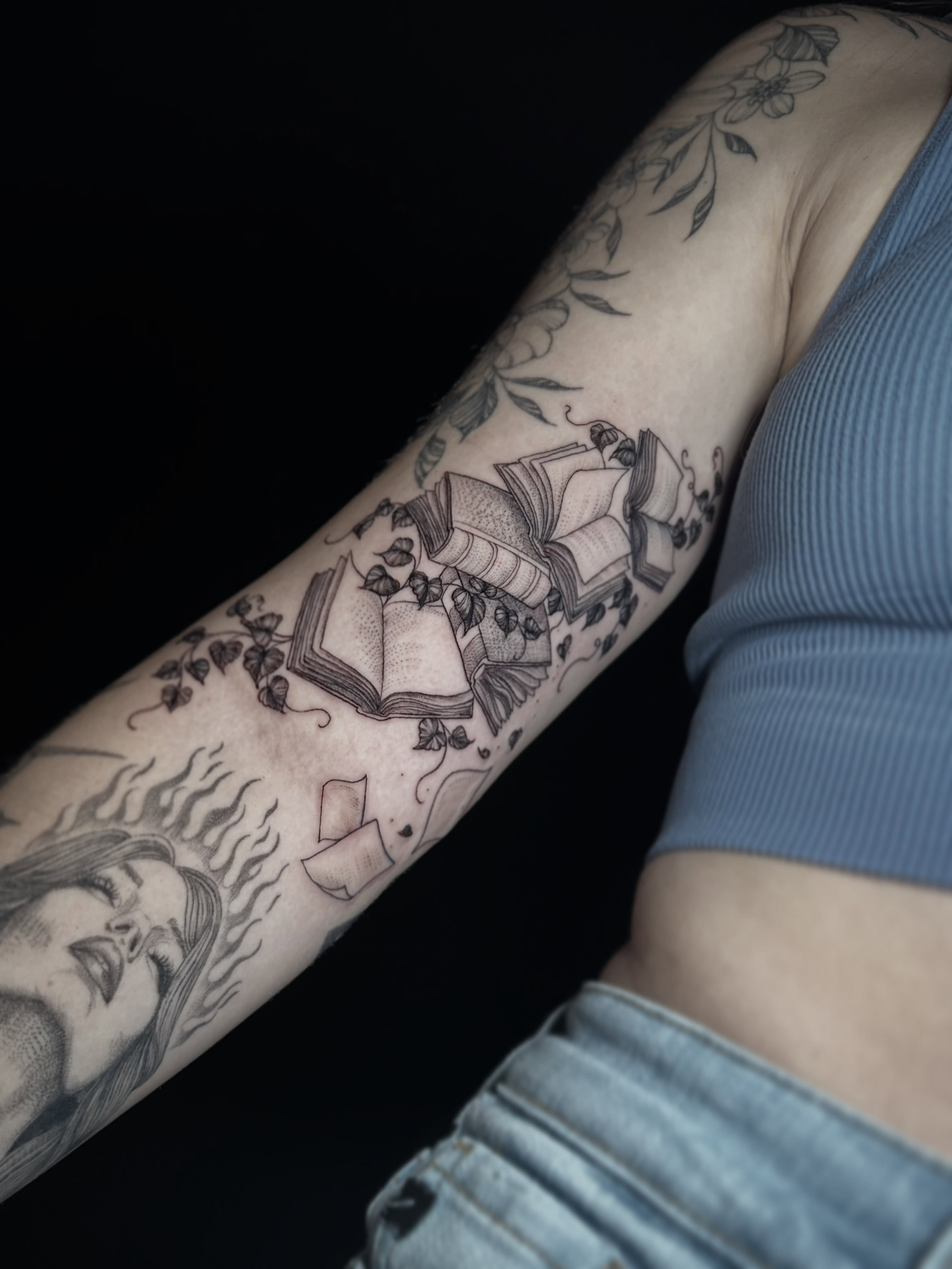 Book and leaves black and grey tattoo on the forearm by Ashlee Mshar