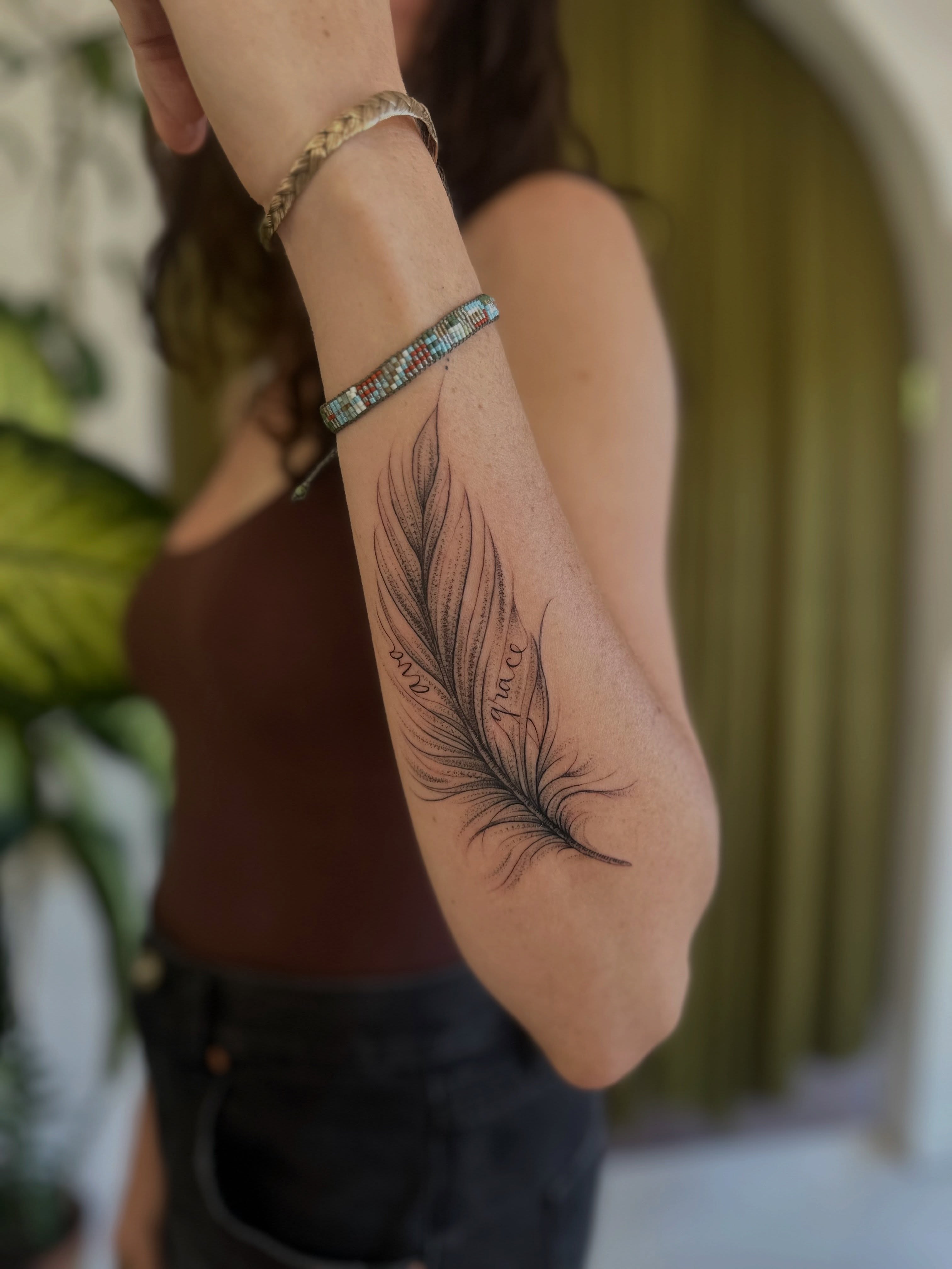 Feather black and grey tattoo on the forearm by Ric Castellon Tattoo Artist, Los Angeles, California