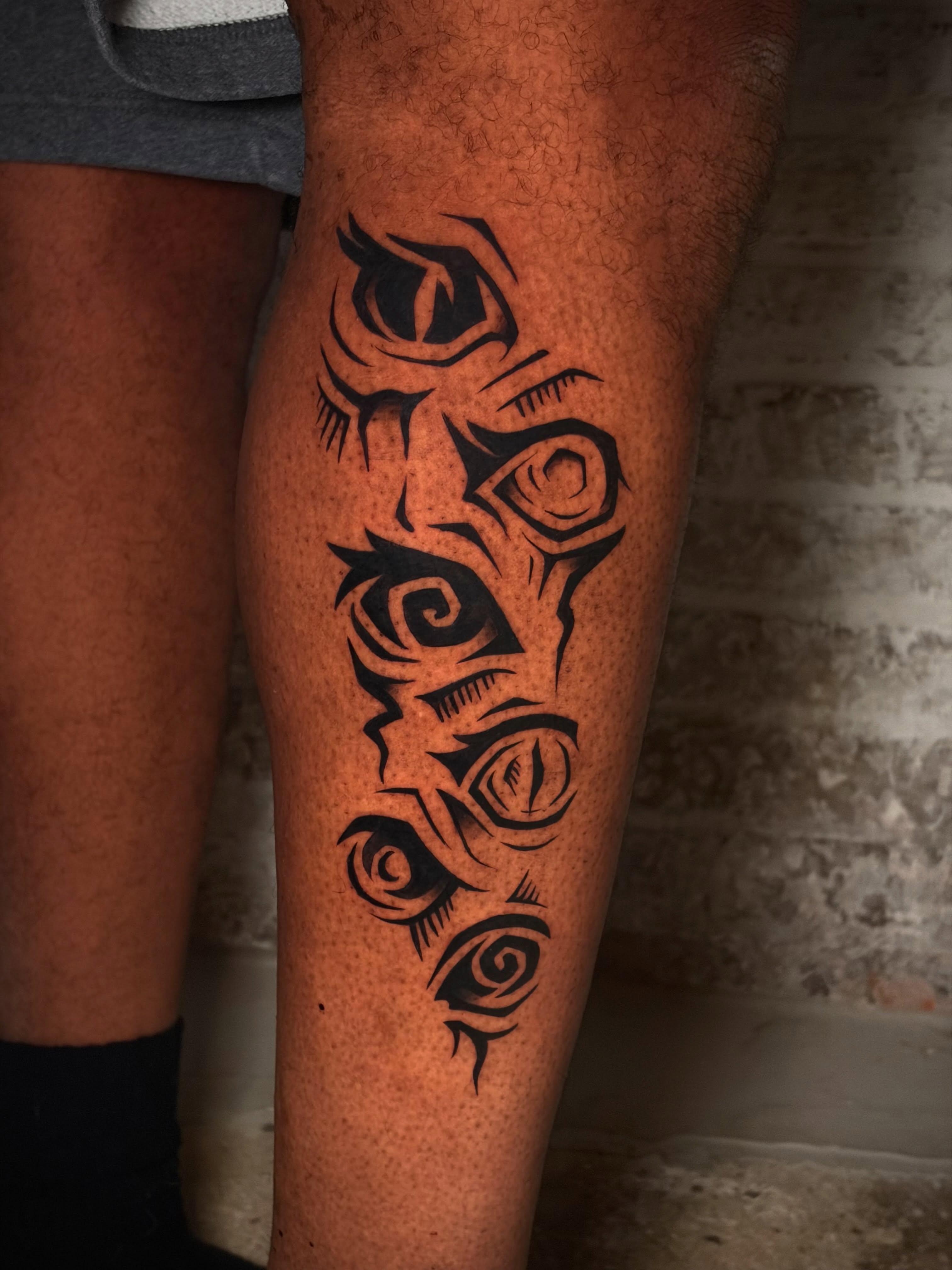 Eyes tribal tattoo on the calf by Musa Selman