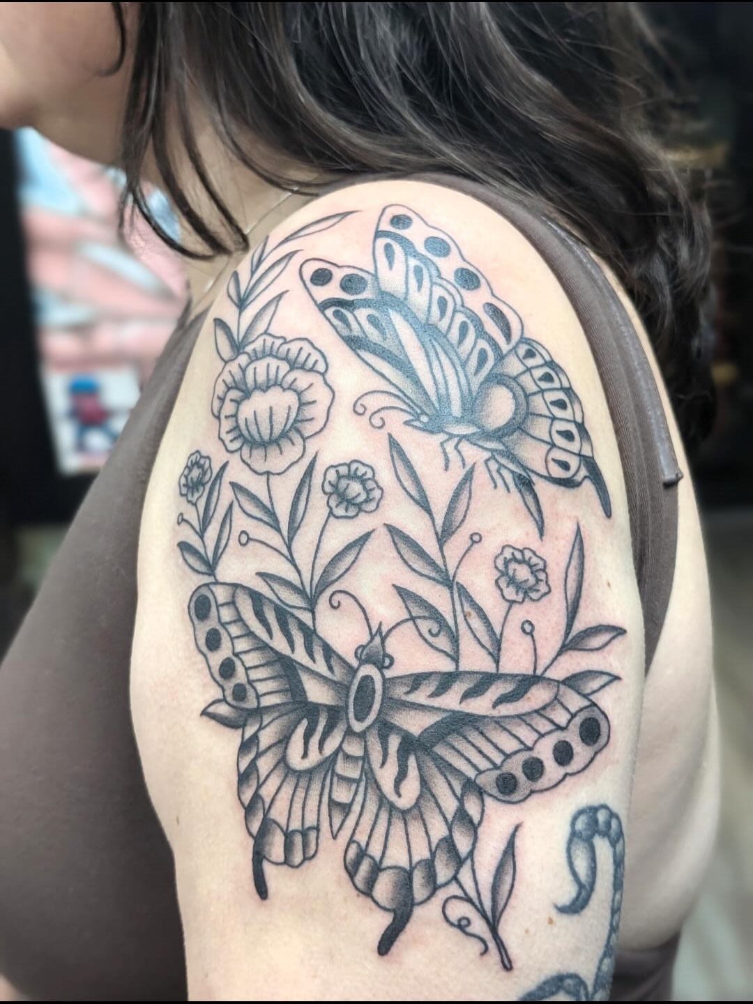 Butterflies and flowers black and grey tattoo on the shoulder by Alexandria Green