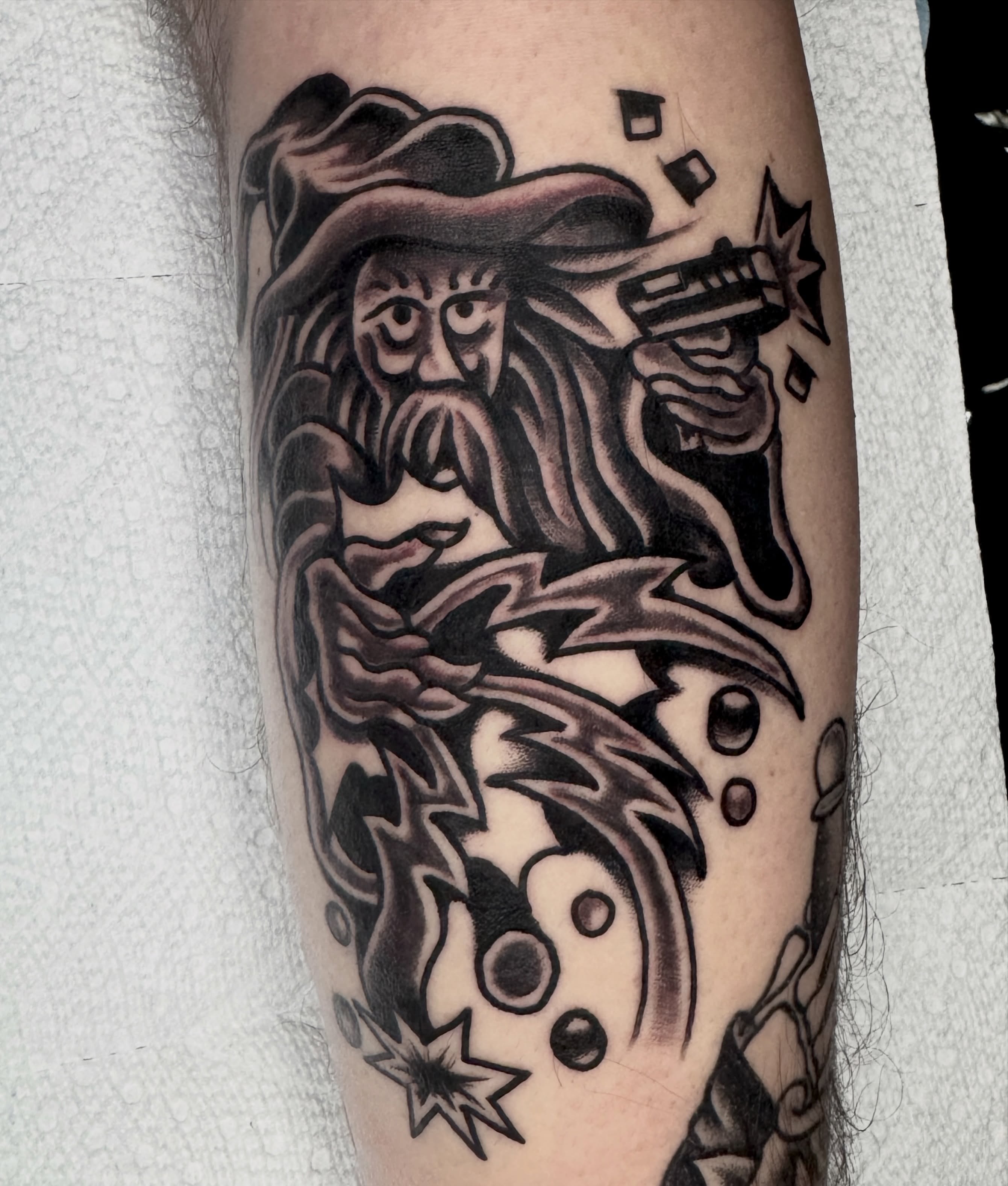 Wizard with gun American traditional tattoo on the forearm by Butz Tattoos