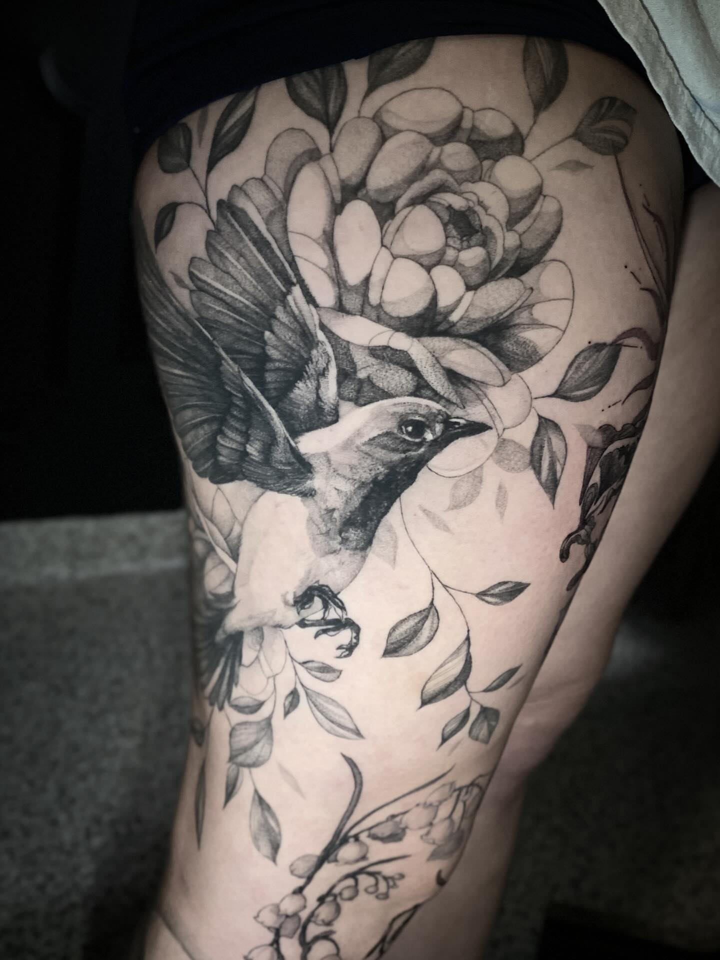 Bird and flower realism tattoo on the thigh by Olivia Scott - Kansas Tattoo Artist