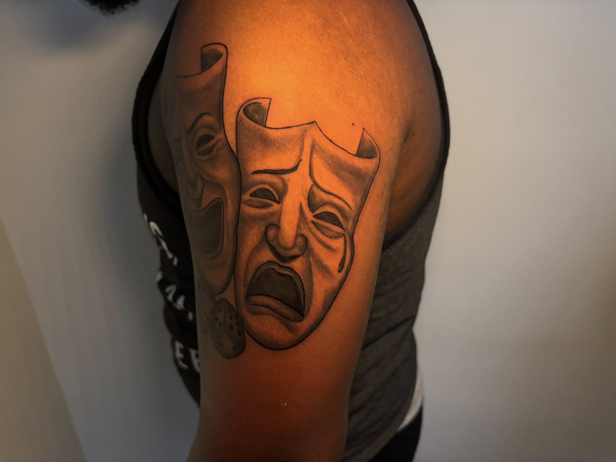 Theater masks black and grey tattoo on the shoulder by Inkys Tatts