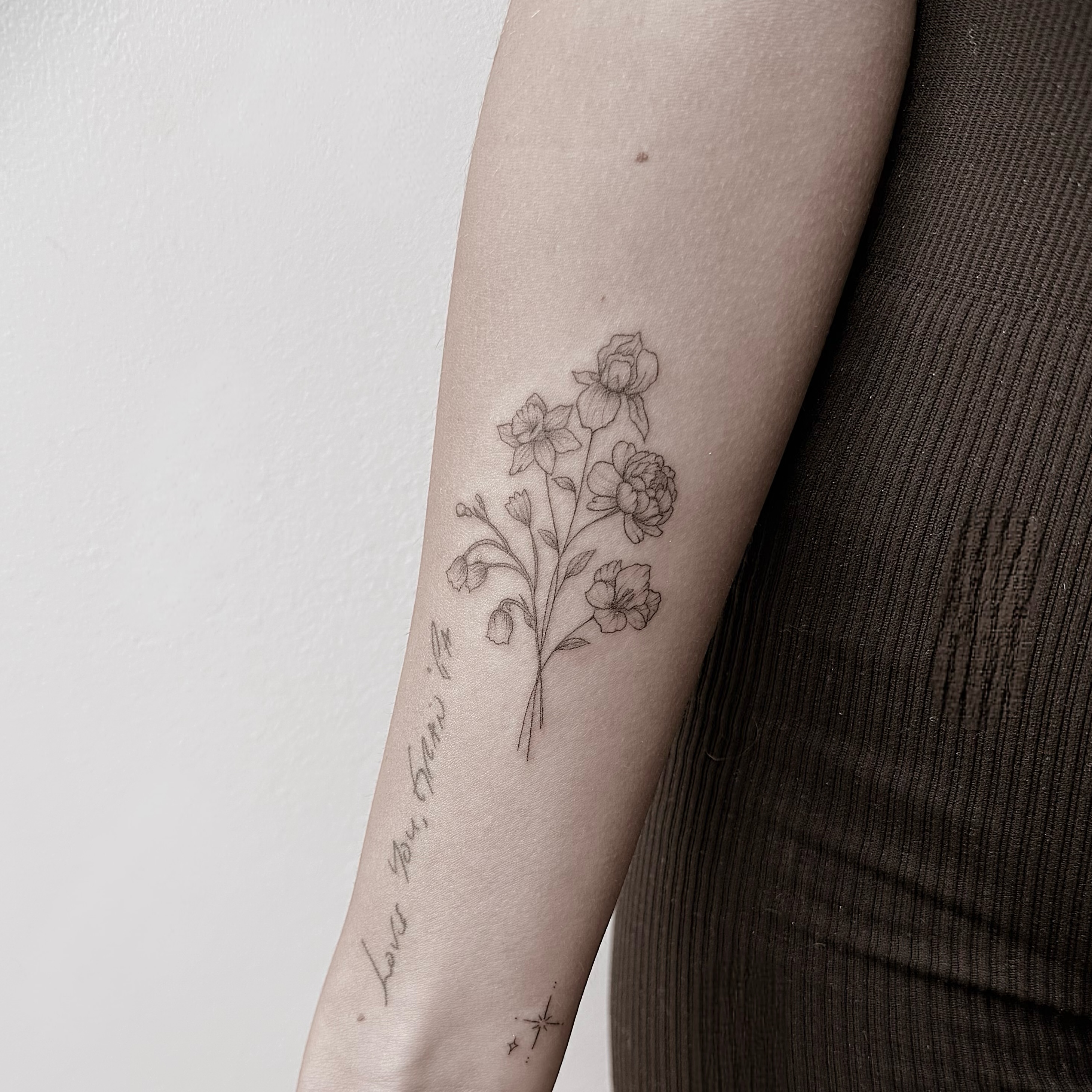 Flowers and script fine line tattoo on the forearm by Chanel Picquelle, Nashville, Tennessee