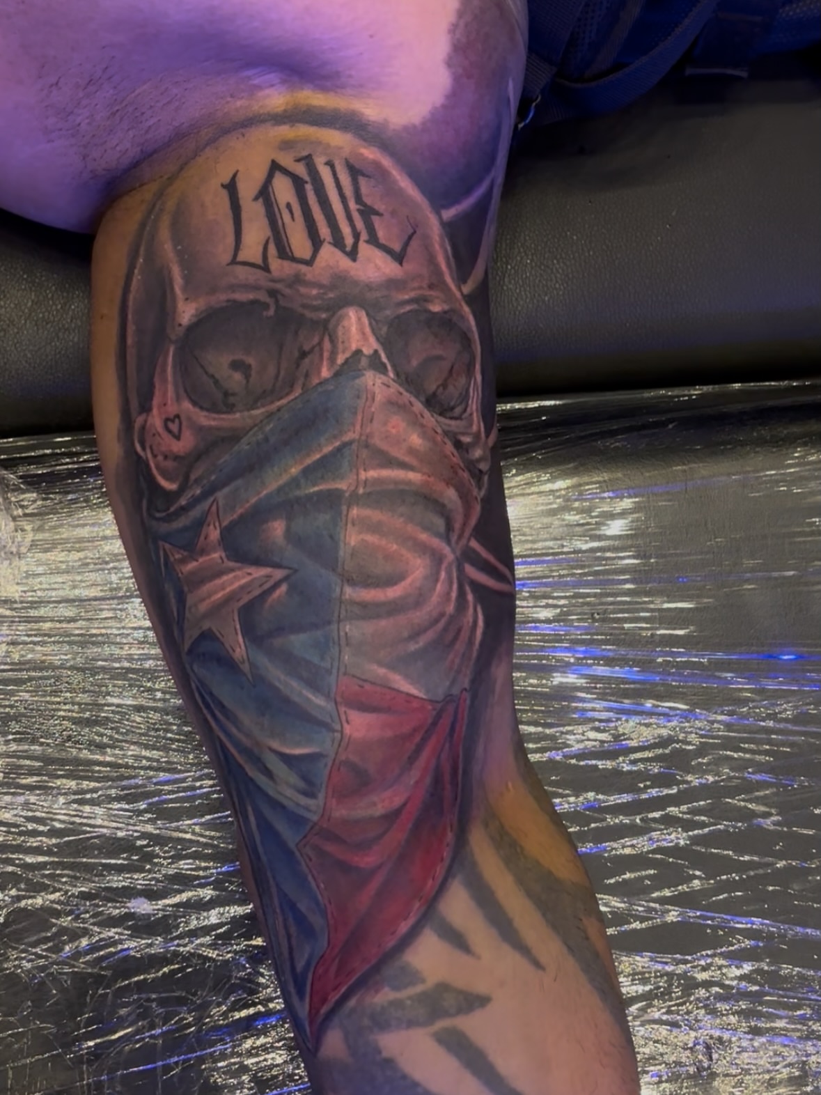 Skull wearing mask realism tattoo on the forearm by Dave