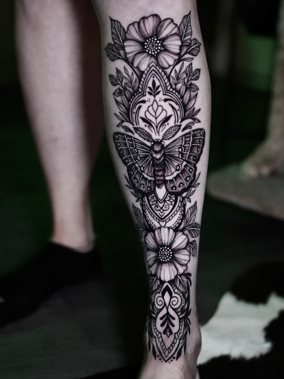 Butterfly and floral ornamental tattoo on the calf by Kirsten Cameron