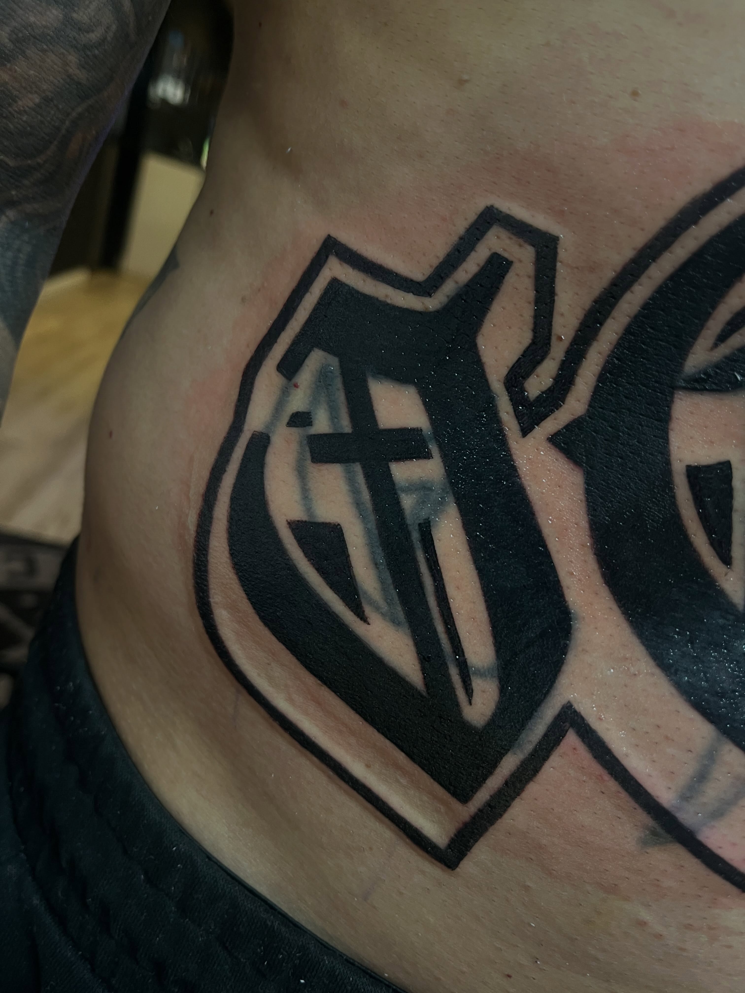 Cross and shield black and grey tattoo on the torso by Kwete Tatuajes