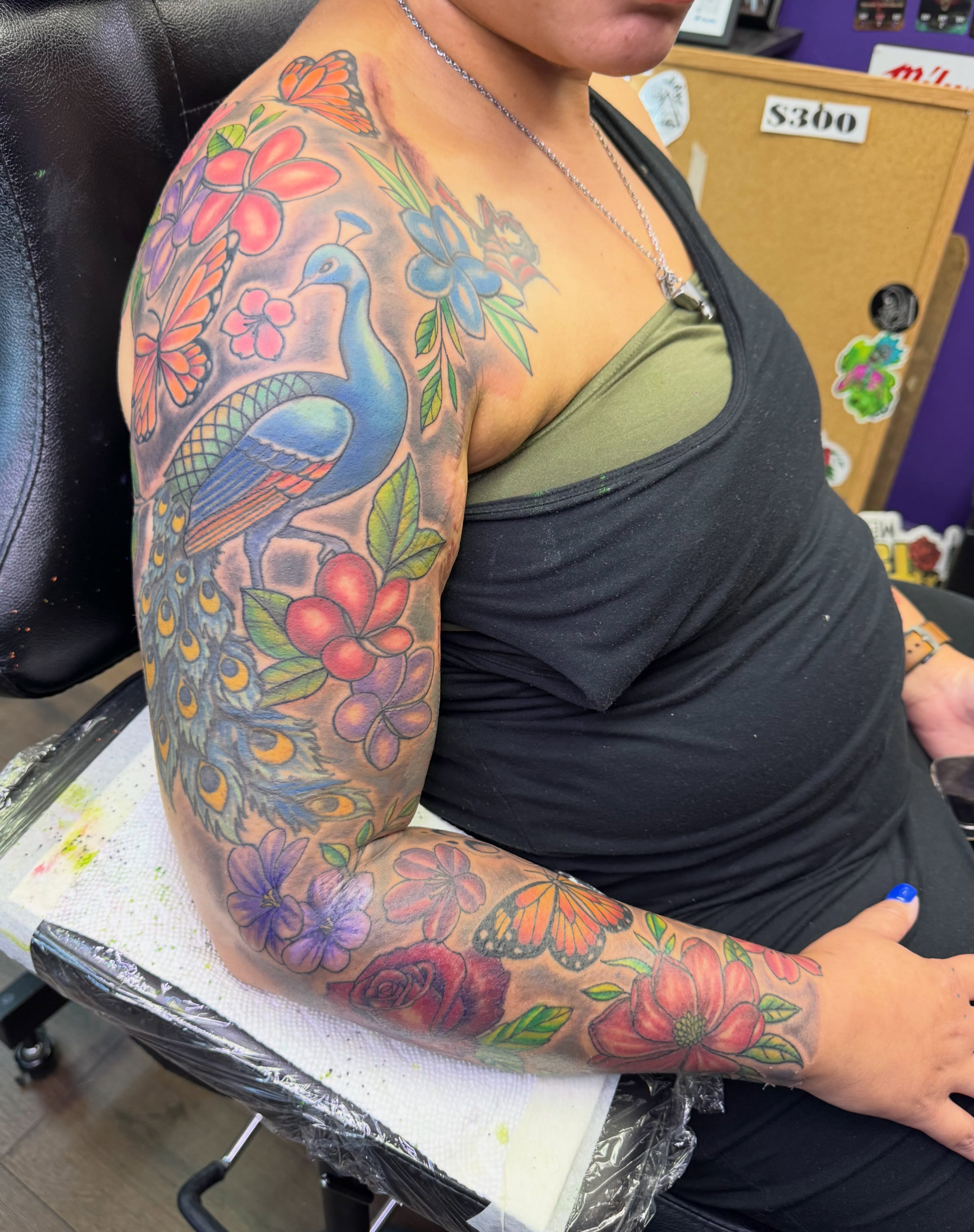 Peacock and floral new school tattoo on the upper arm by Christian Goines, Memphis, Tennessee