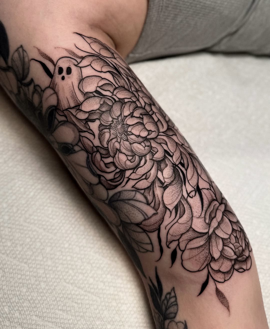 Ghost and flowers black and grey tattoo on the forearm by Jessica Bloom