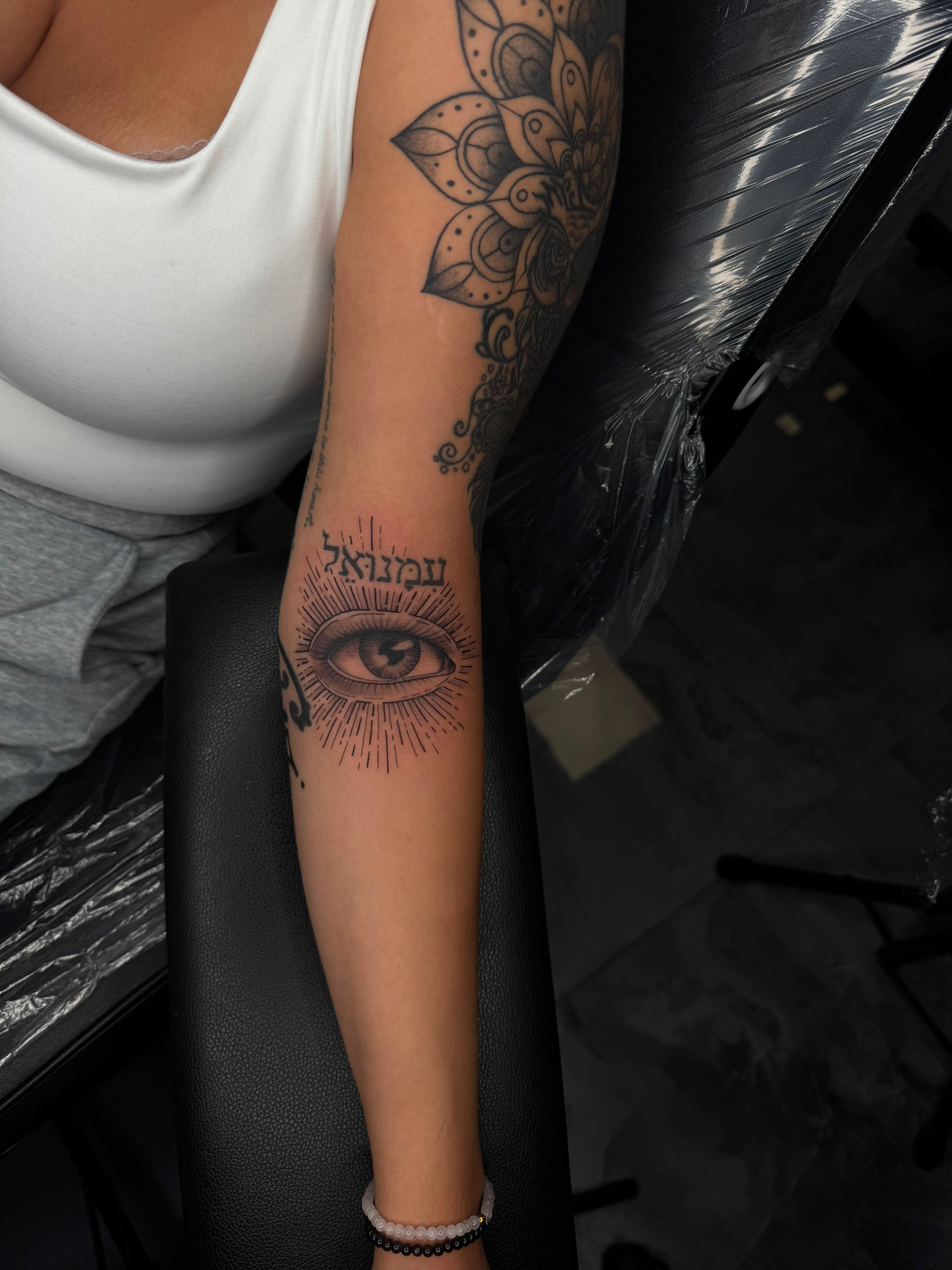 Eye with Hebrew text black and grey tattoo on the forearm by Exis LHinc, Miami, Florida