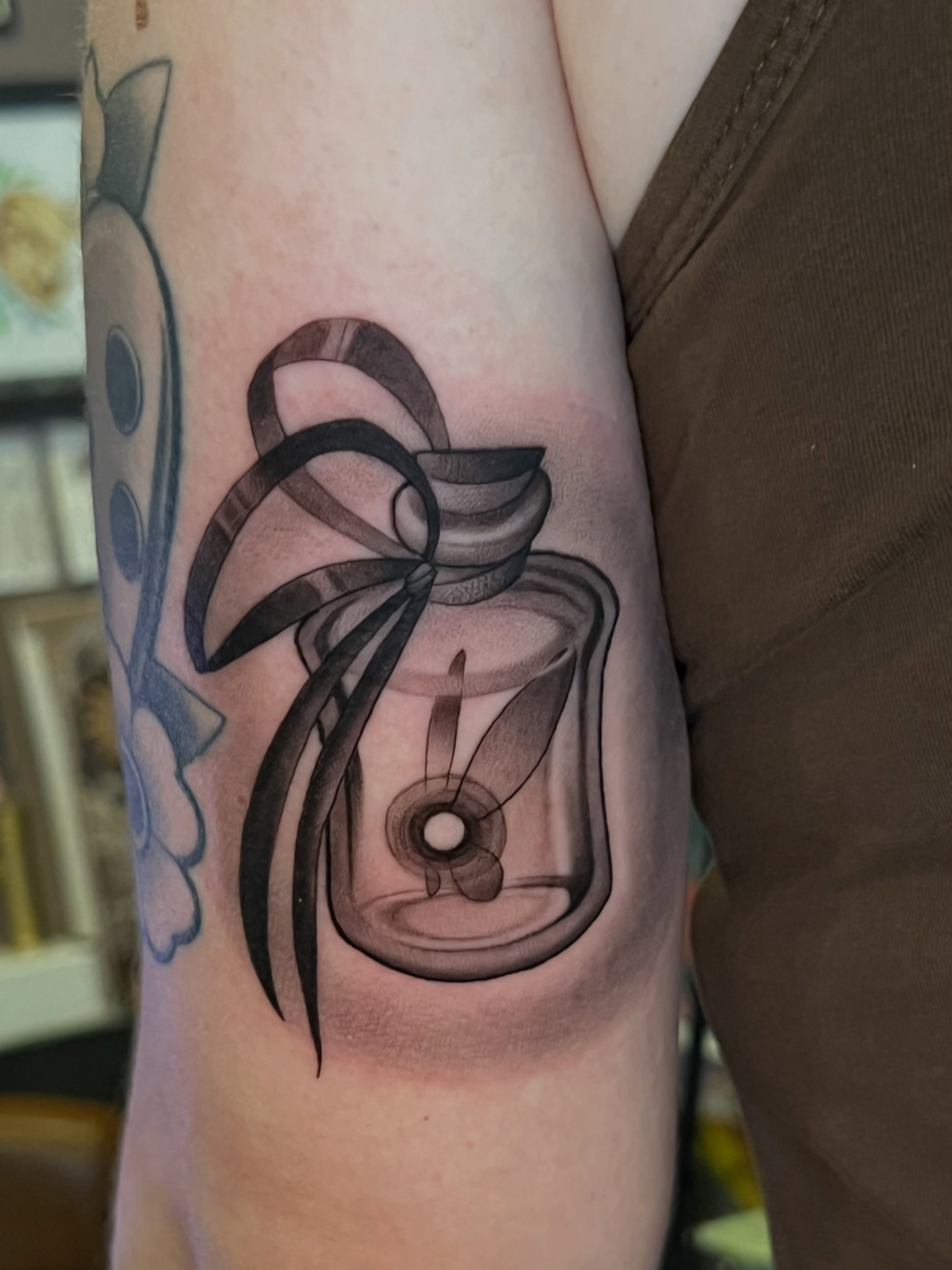 Mason jar with candle black and grey tattoo on the forearm by Millie, Maryville, Tennessee