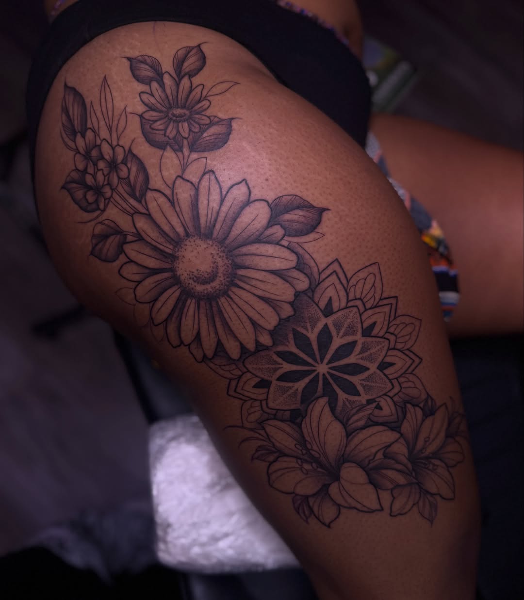 Sunflower and floral bouquet black and grey tattoo on the thigh by Charlotte Nc📍tattoo Artist
