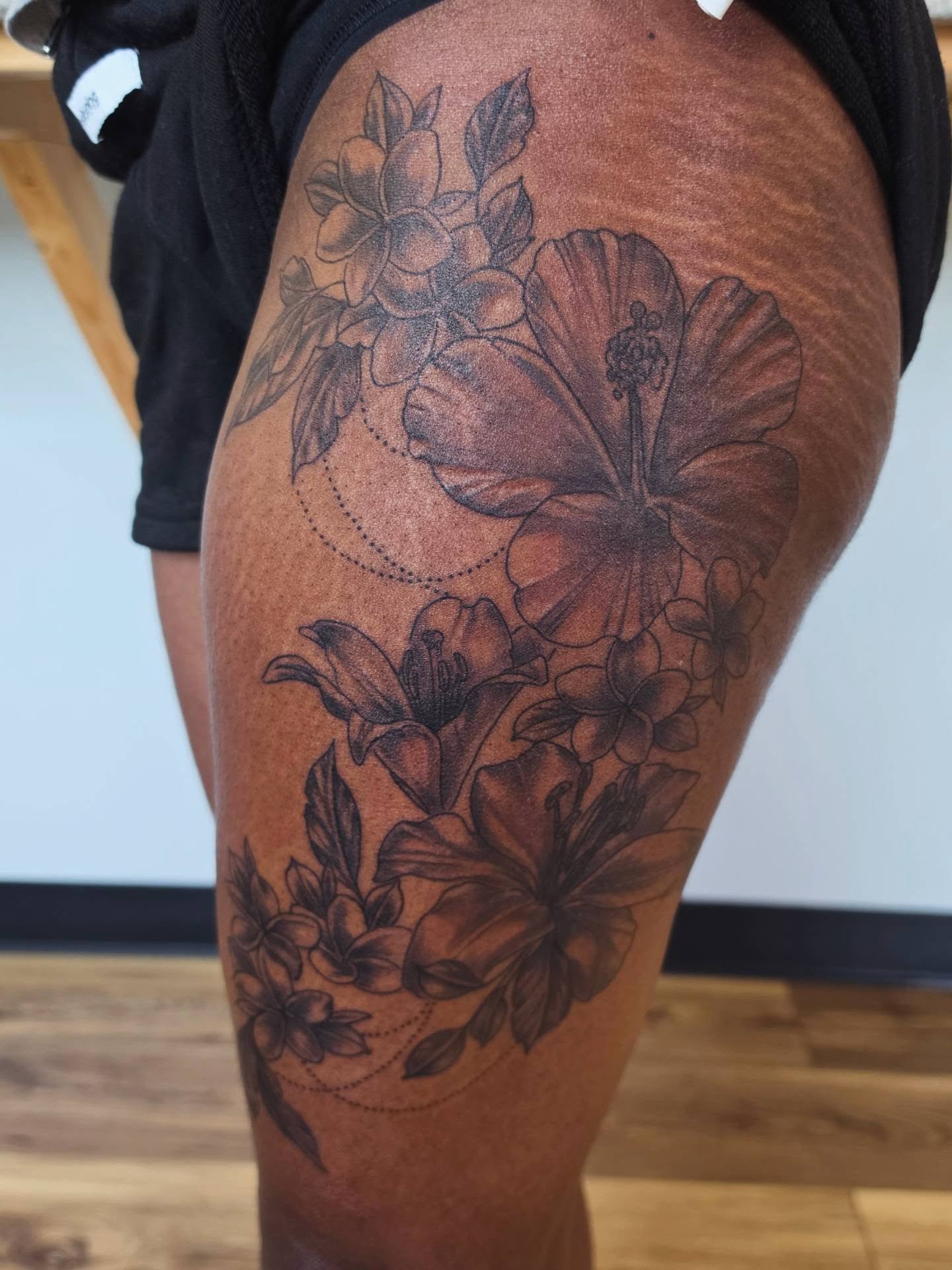 Floral arrangement realism tattoo on the thigh by Colleen