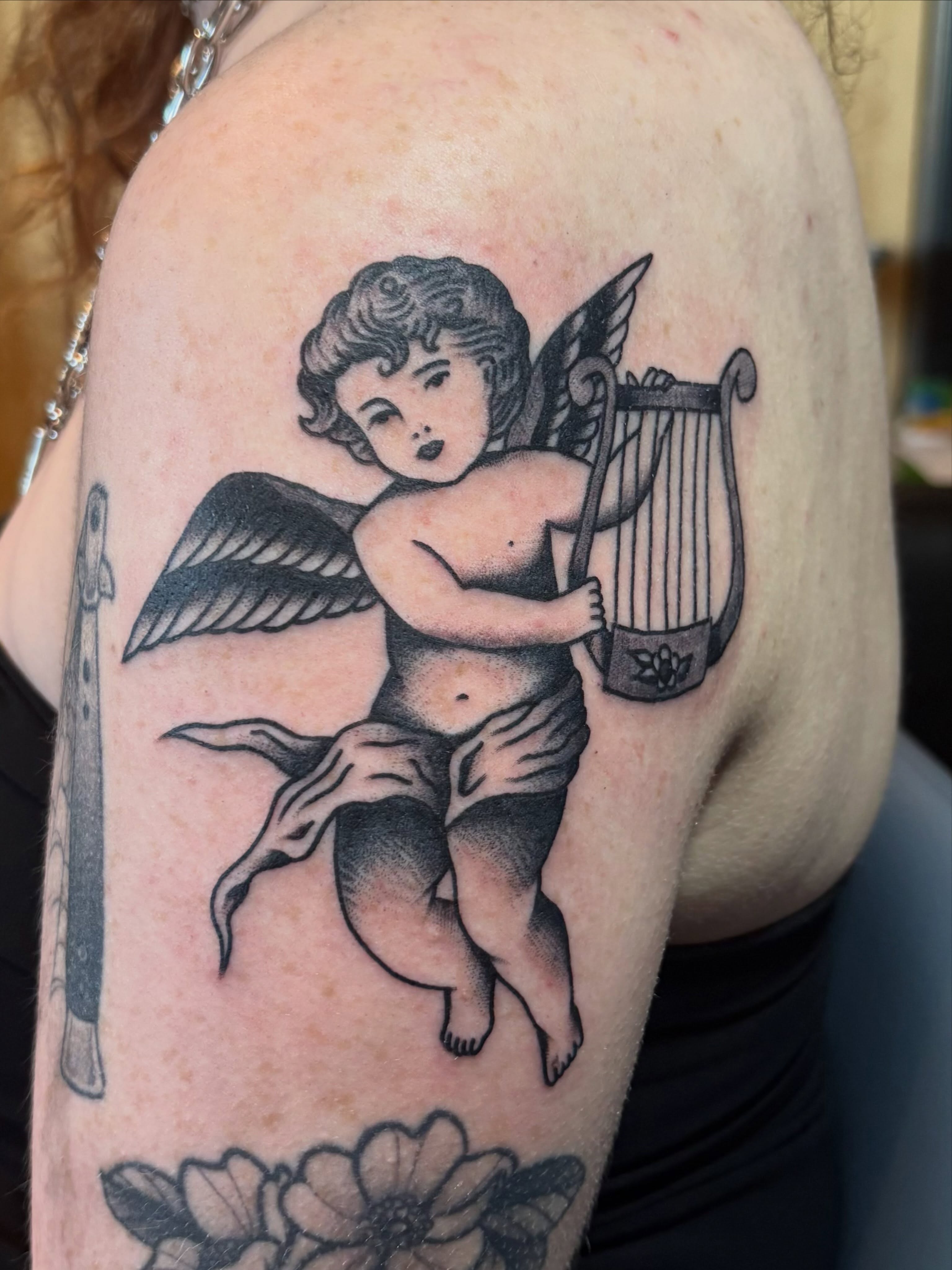 Cherub playing lyre American traditional tattoo on the shoulder by Izzy