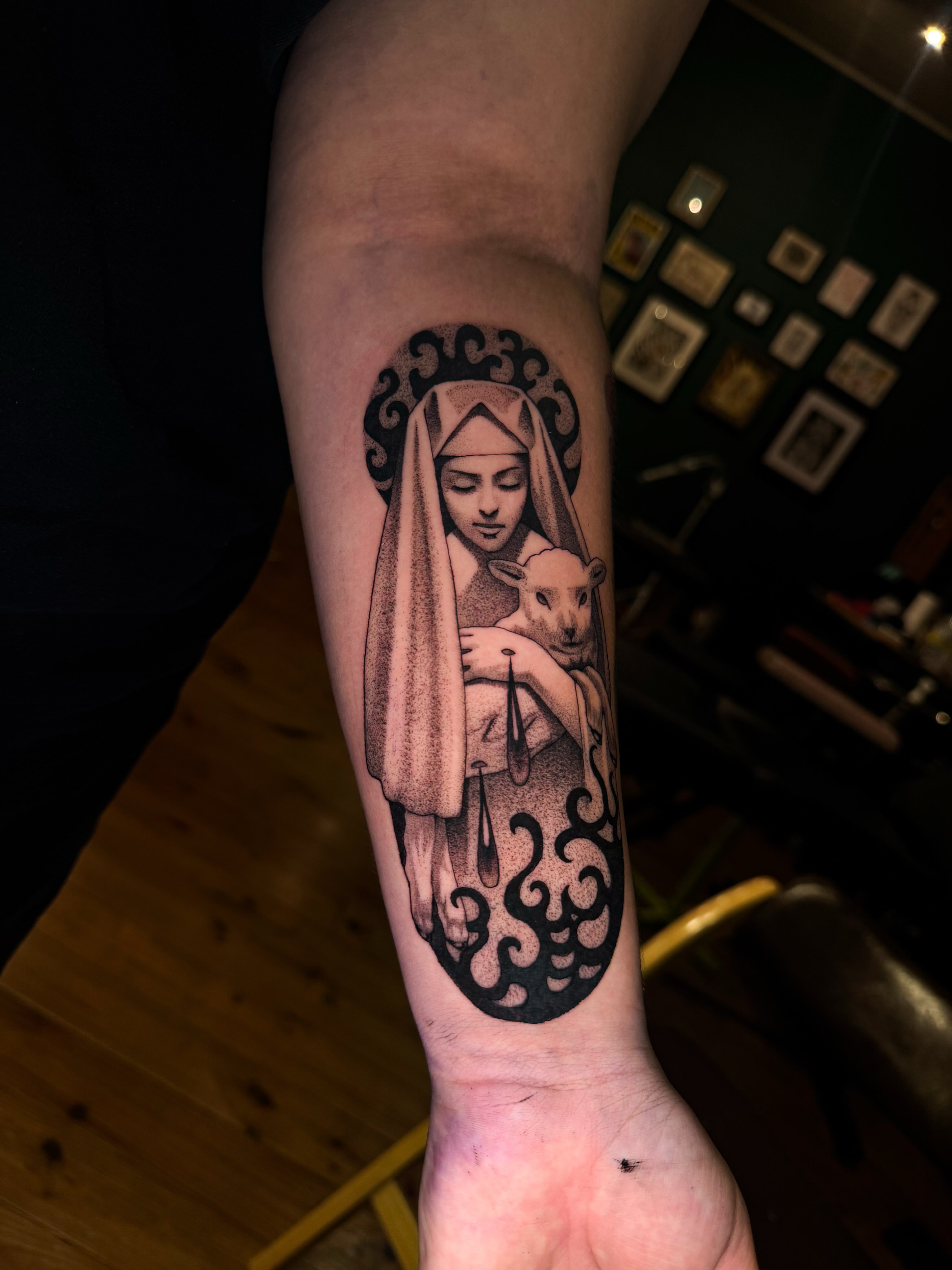 Religious figure with lamb dotwork tattoo on the forearm by Marina Spell