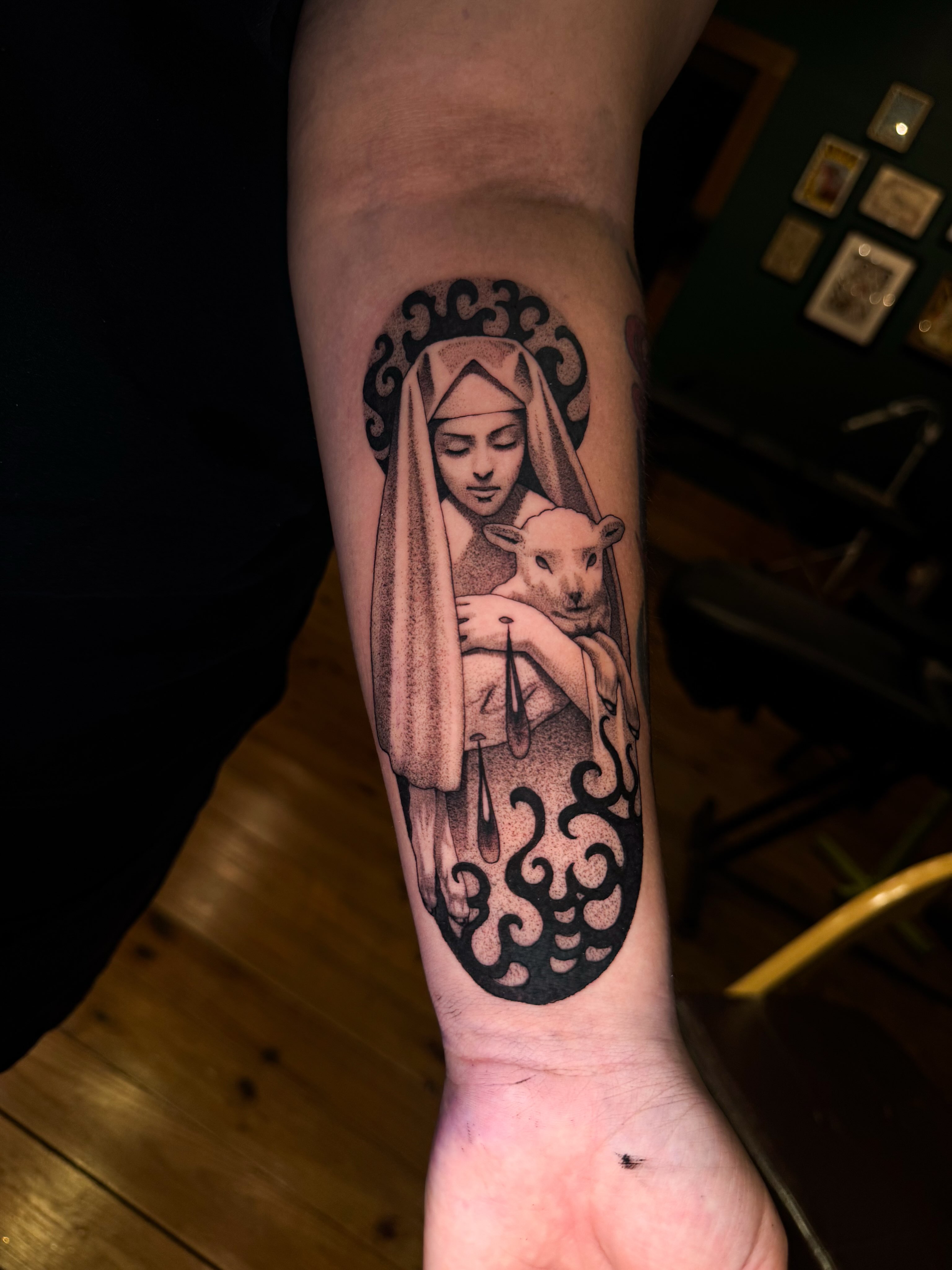 Religious figure with lamb dotwork tattoo on the forearm by Marina Spell