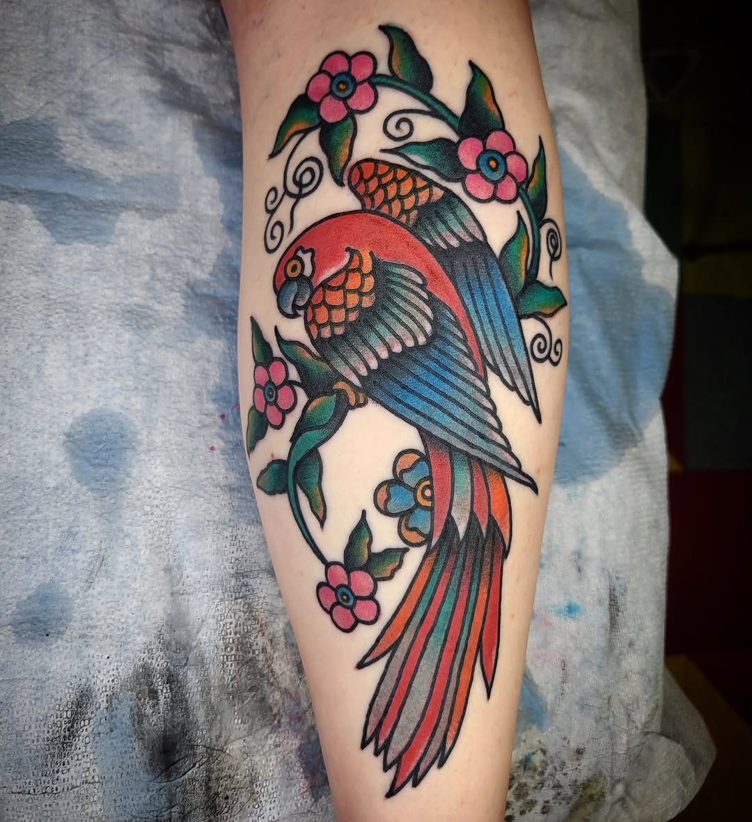 Parrot and flowers American traditional tattoo on the forearm by joe martinez, Denver, Colorado