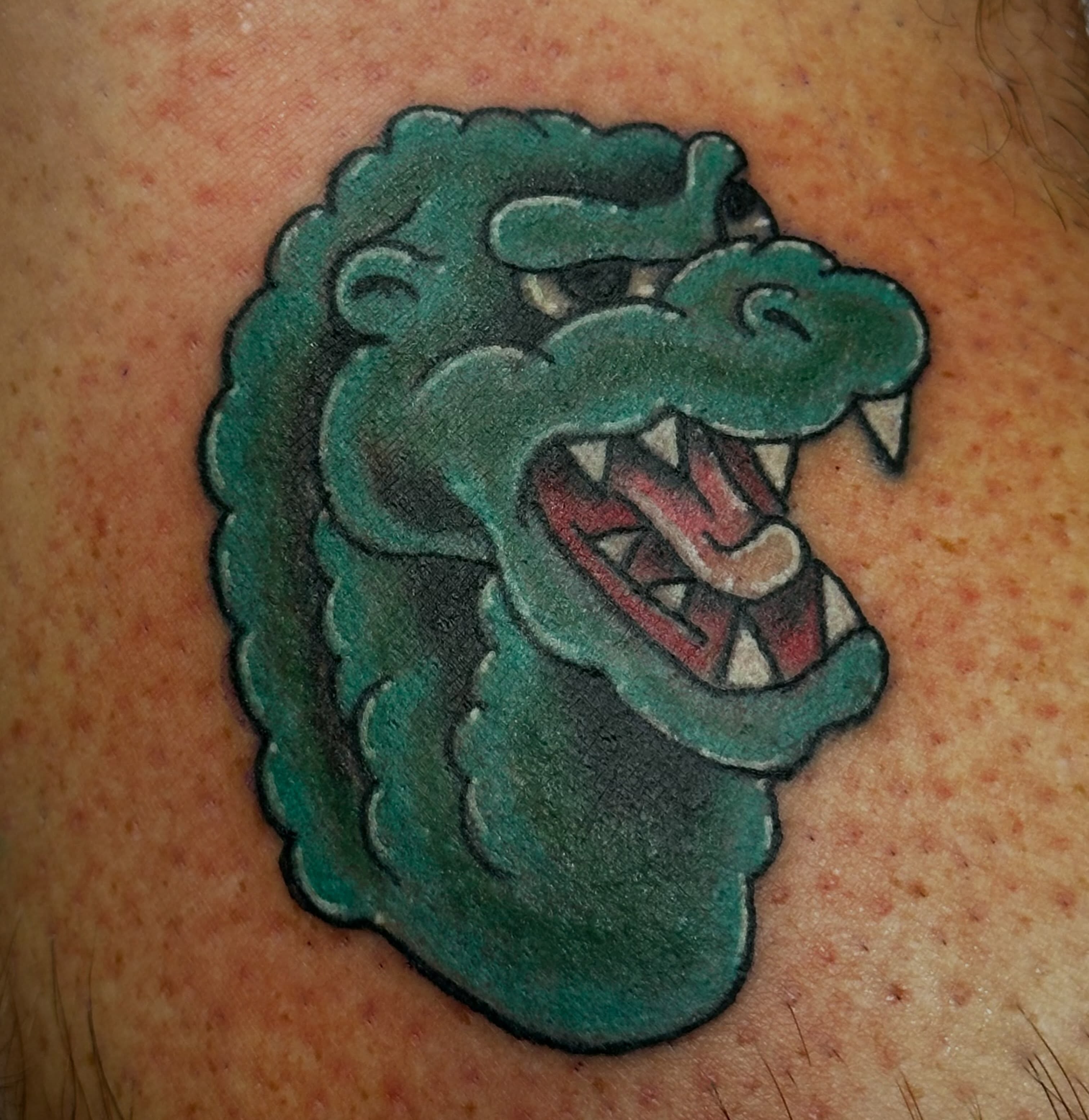 Alligator American traditional tattoo on the upper arm by Wesley Lam