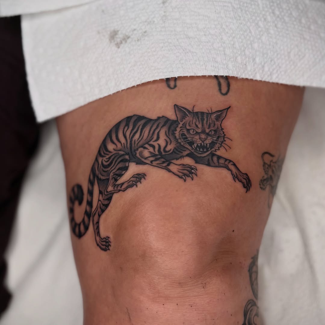 Cat black and grey tattoo on the thigh by Lauren Dempsey, Dearborn, Michigan