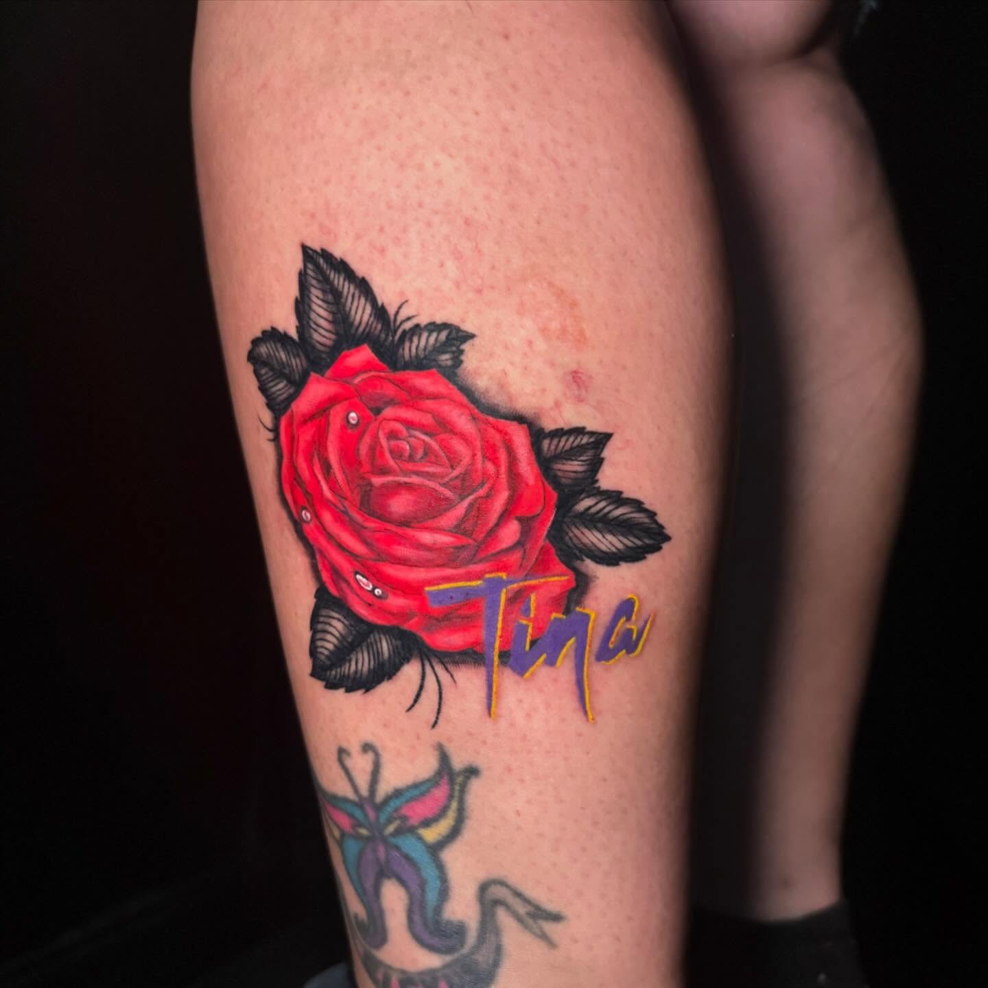 Red rose realism tattoo on the thigh by Nina Rush