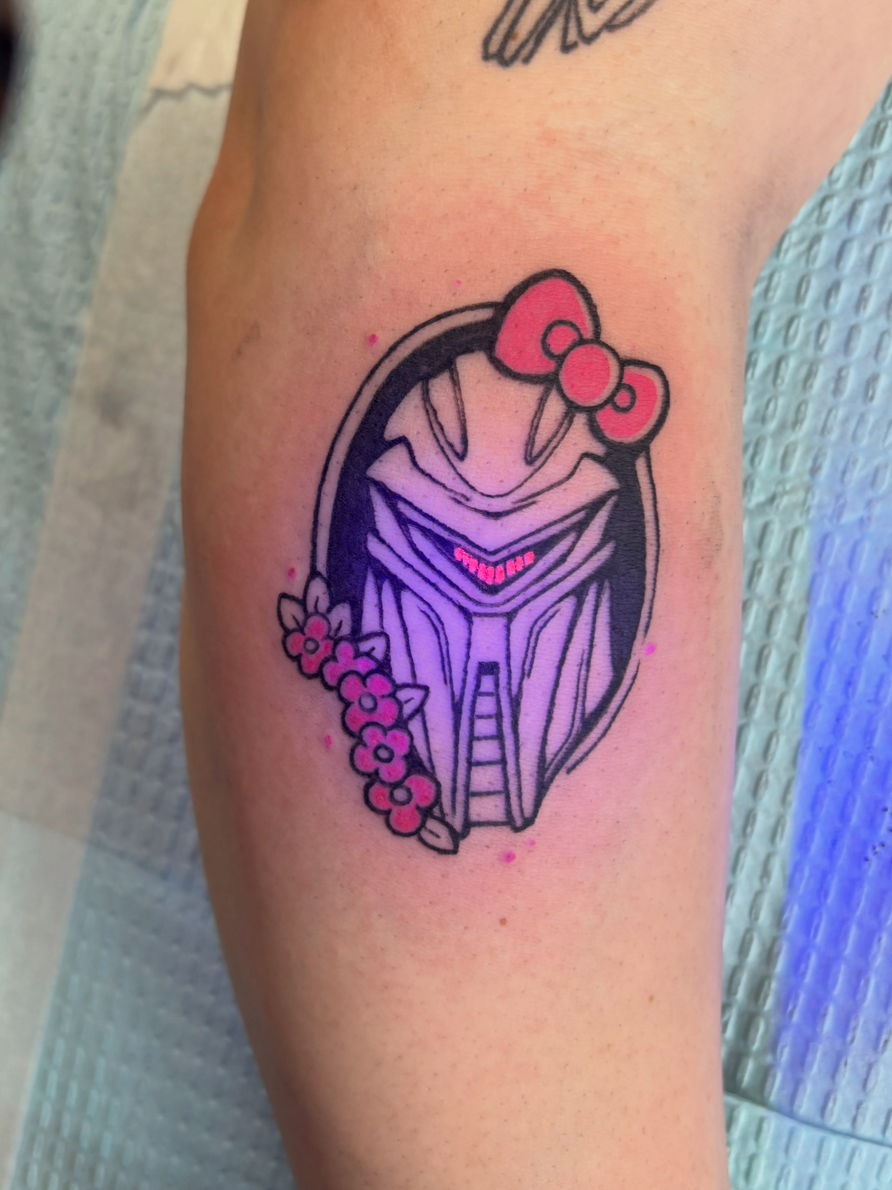 Mandalorian helmet anime tattoo on the forearm by Zoe Brookes