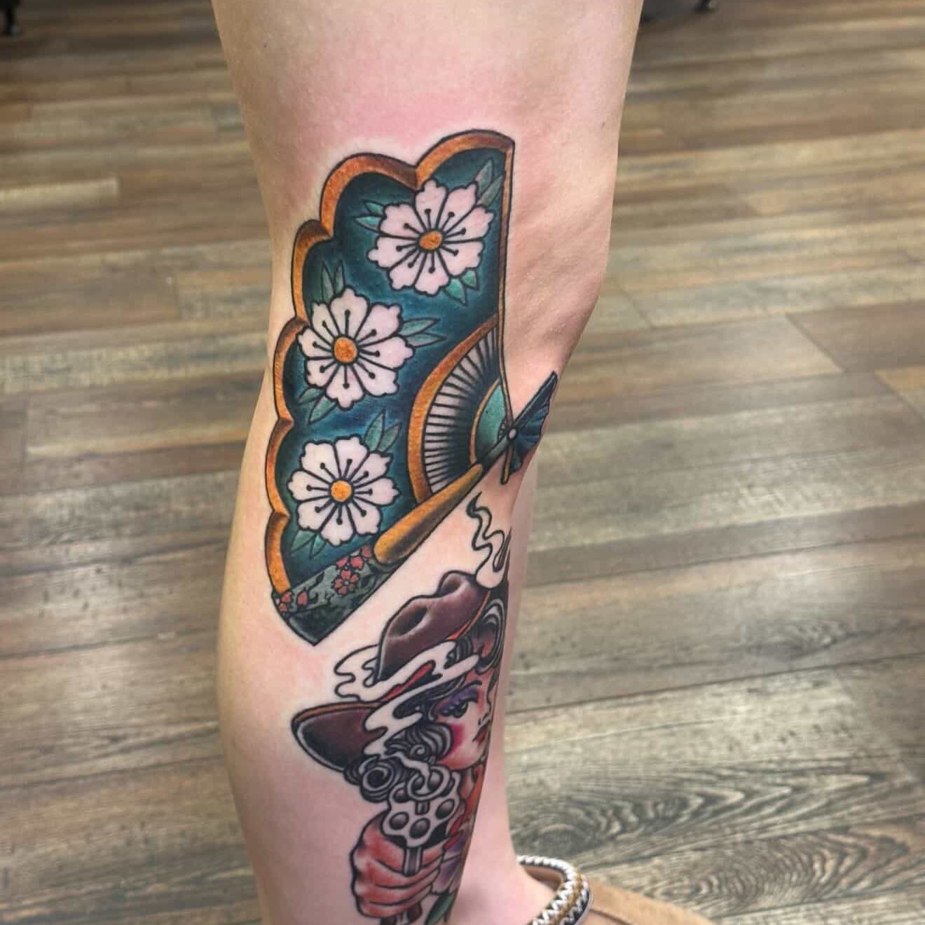 Floral fan and woman American traditional tattoo on the calf by Isaac Ortiz-Riendeau