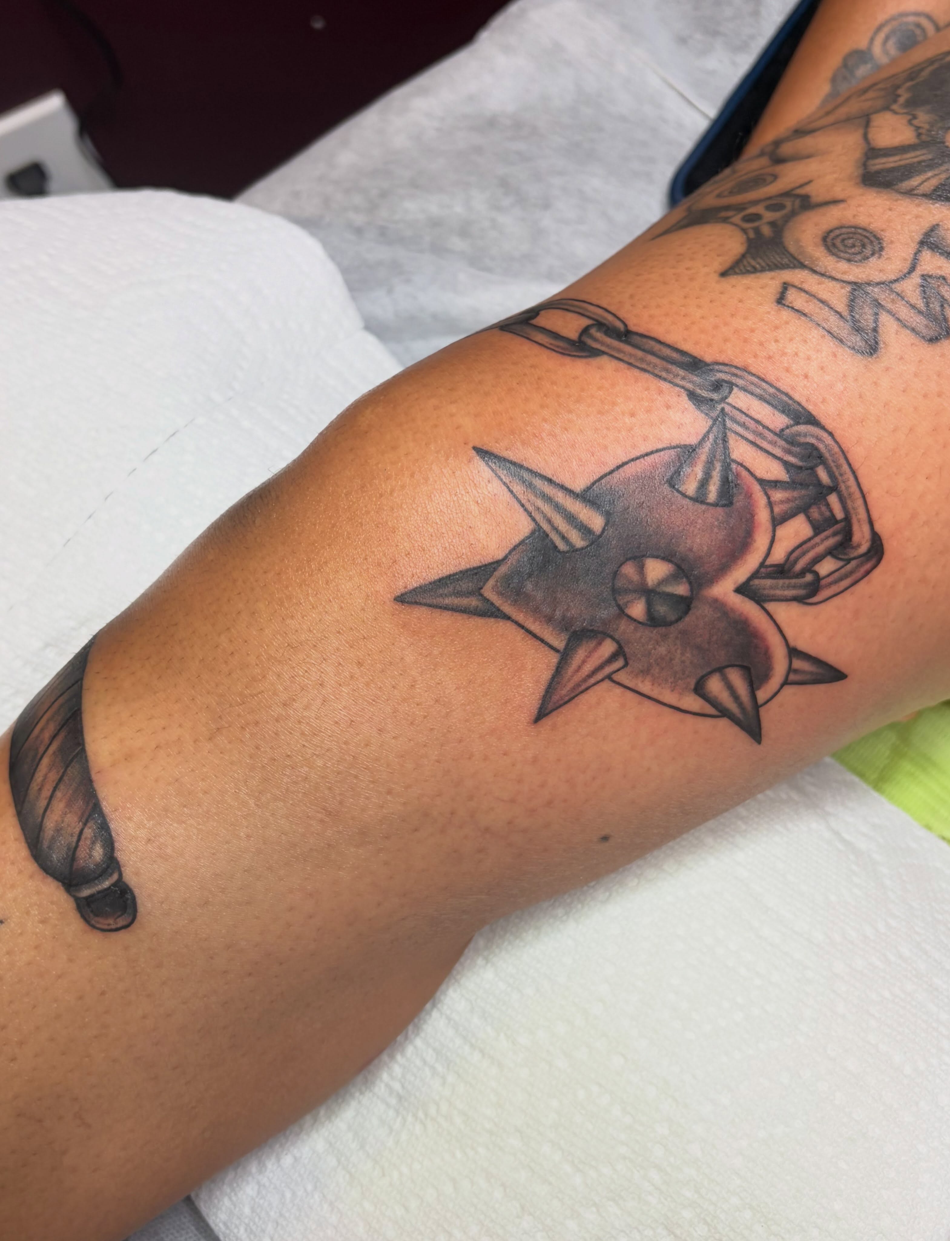 Shuriken black and grey tattoo on the forearm by Mary Hannah Sosdian
