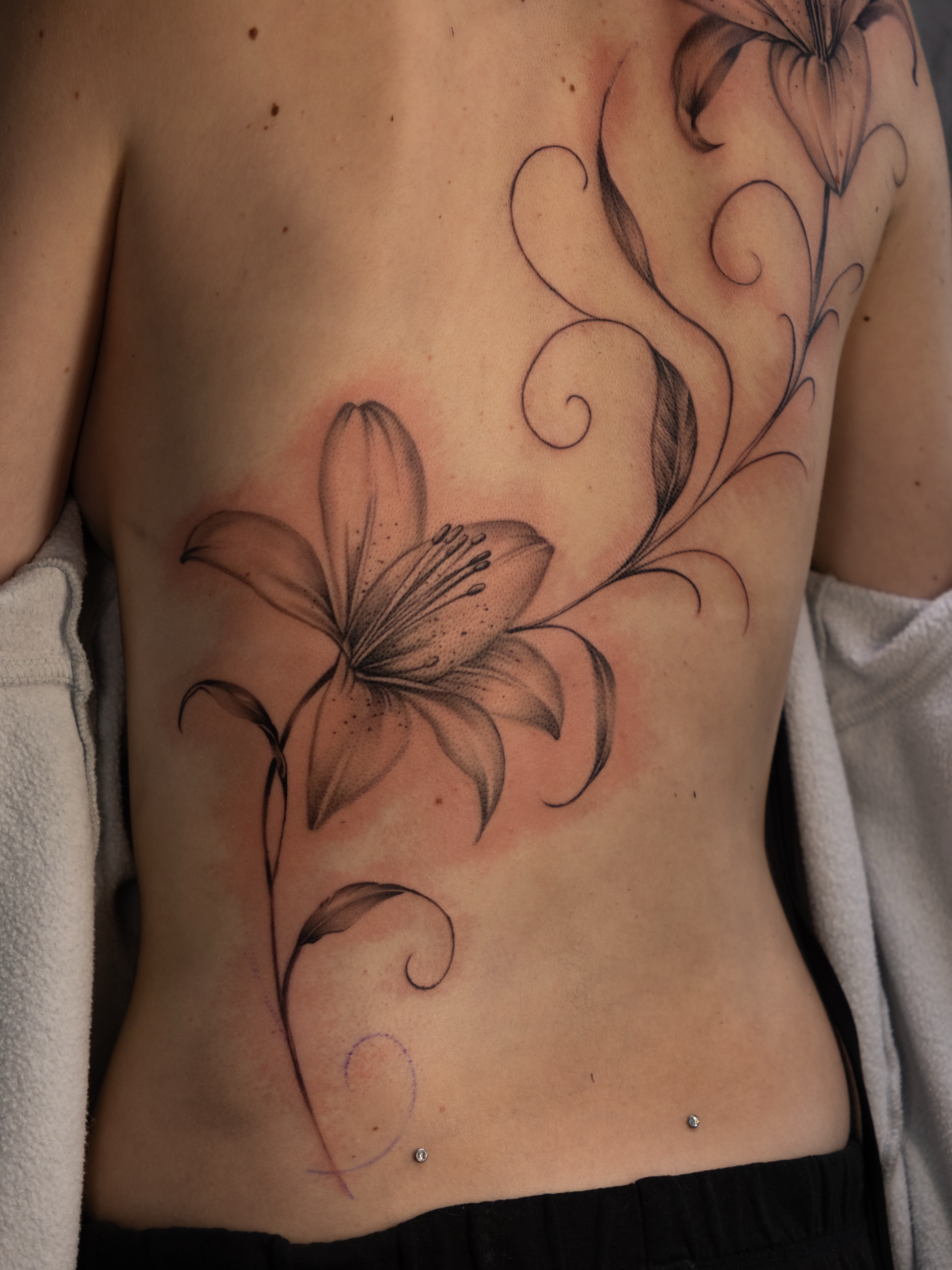 Lily black and grey tattoo on the ribs by Damon Valdez