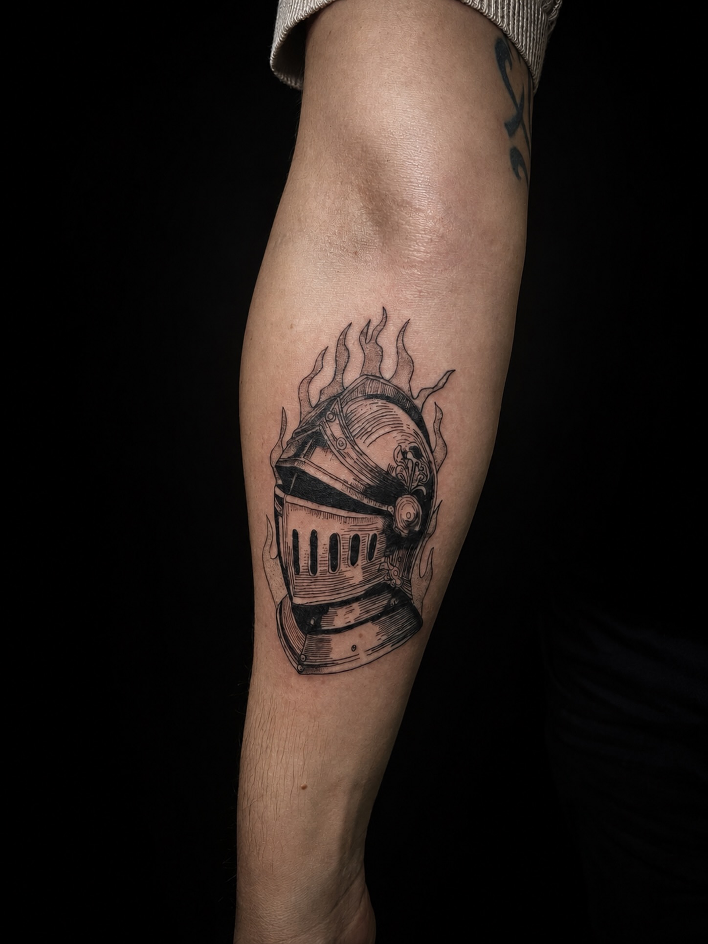 Knight helmet black and grey tattoo on the forearm by 𝚃𝙰𝚃𝚃𝙾𝙾 𝙰𝚁𝚃𝙸𝚂𝚃, Charlotte, North Carolina