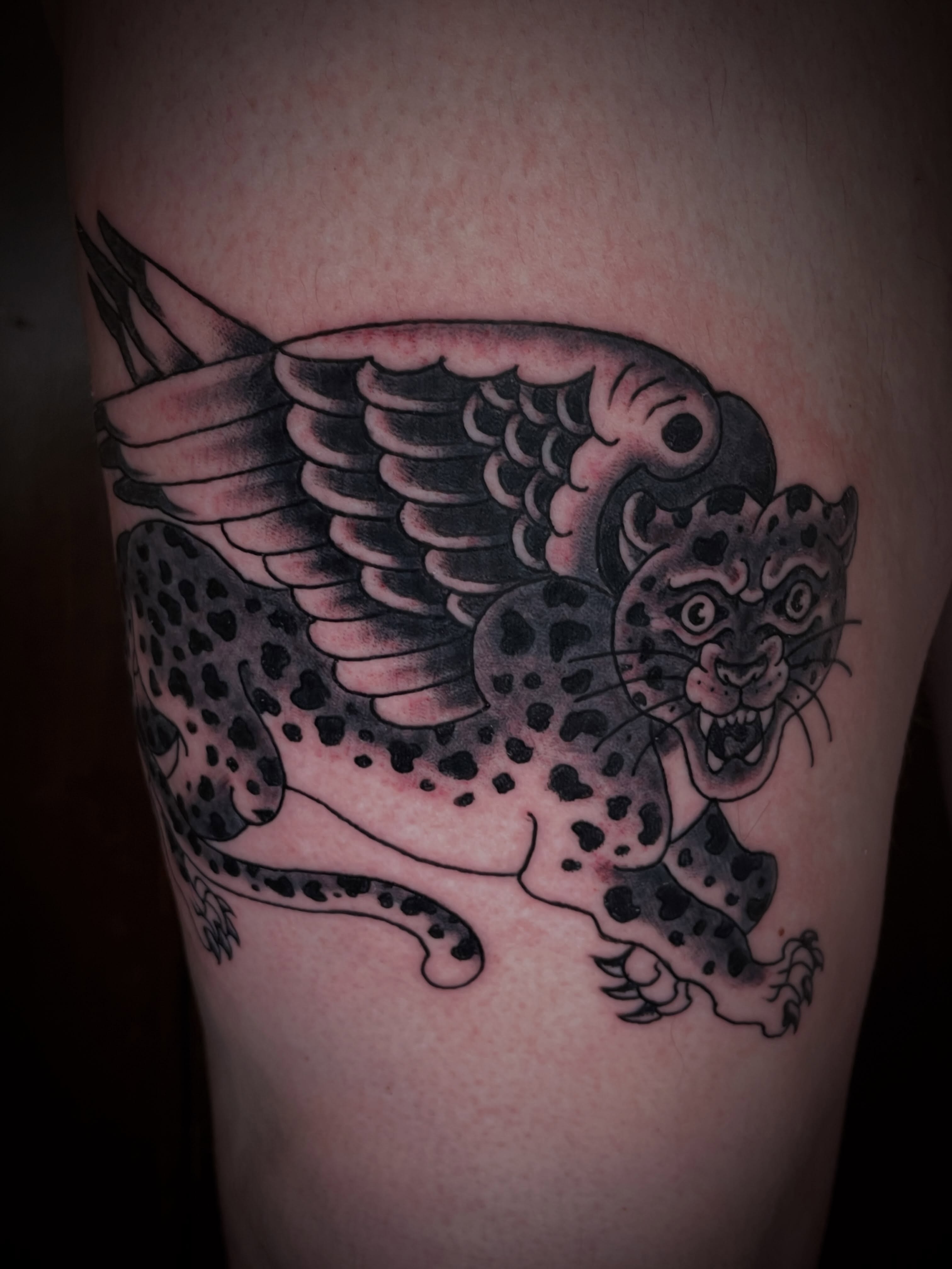 Winged leopard American traditional tattoo on the thigh by Nick Wallin