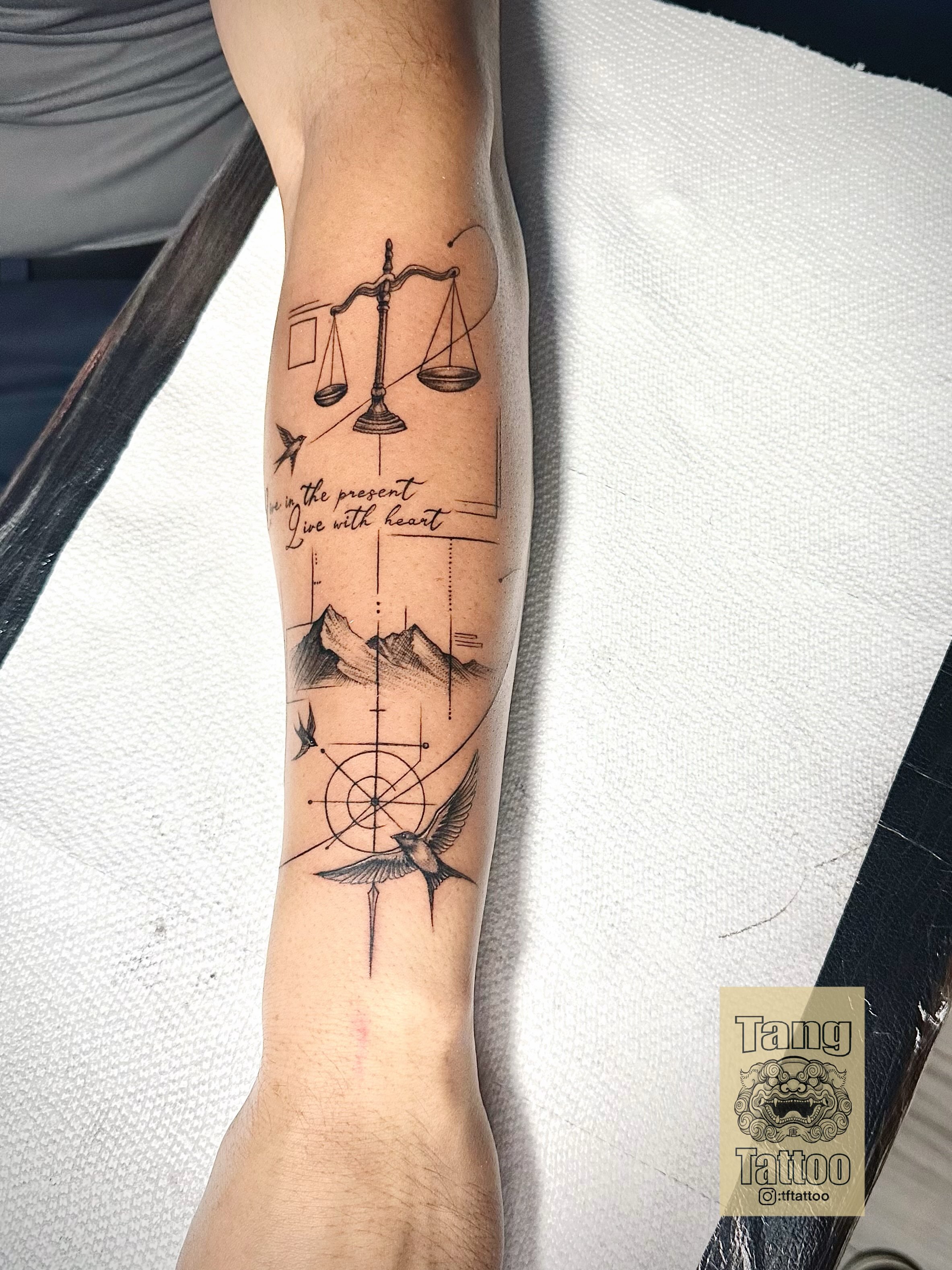 Scale, birds, mountains, compass, text geometric tattoo on the forearm by Tang tattoo, Houston, Texas