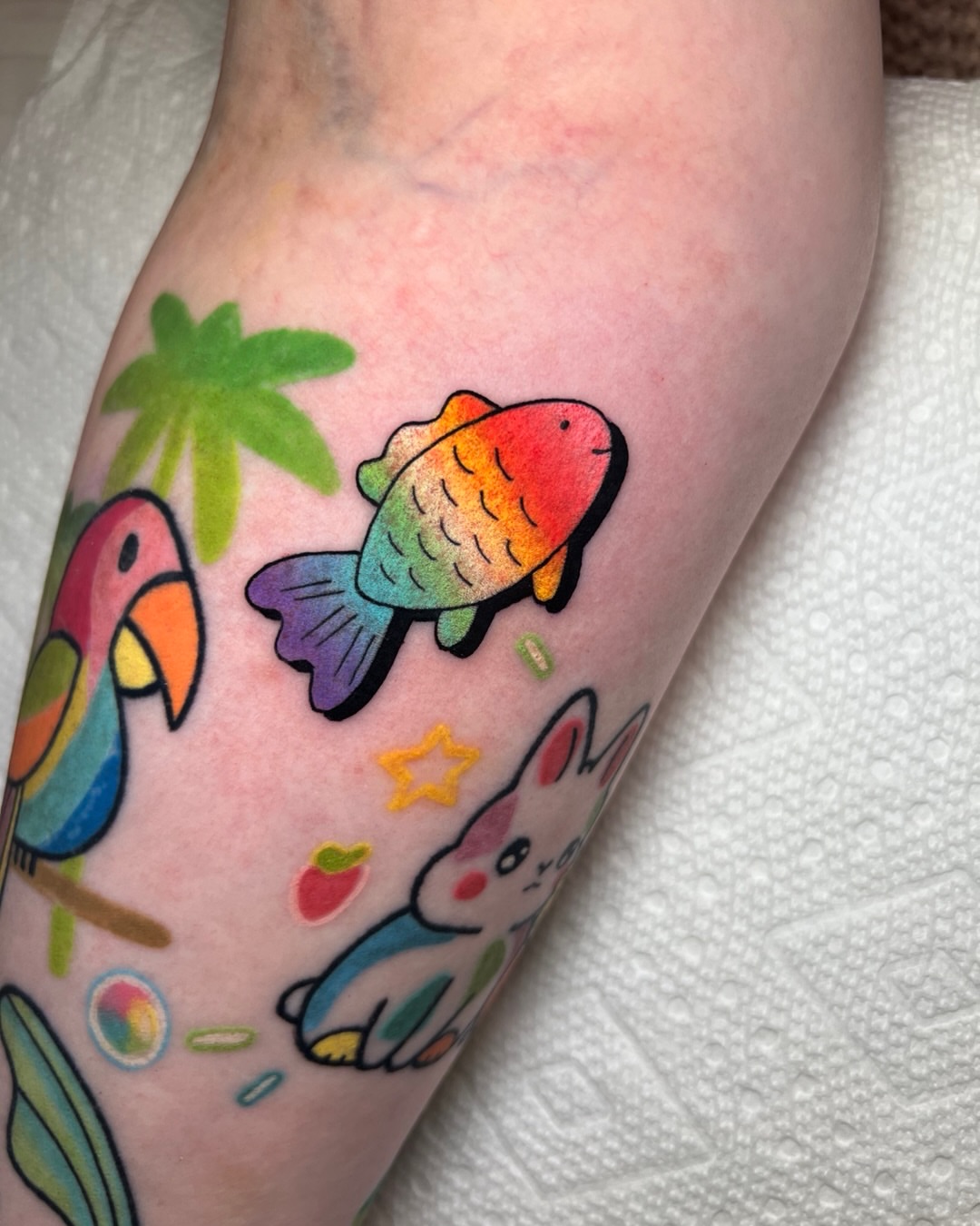 Rainbow fish new school tattoo on the forearm by Tattoo Artist