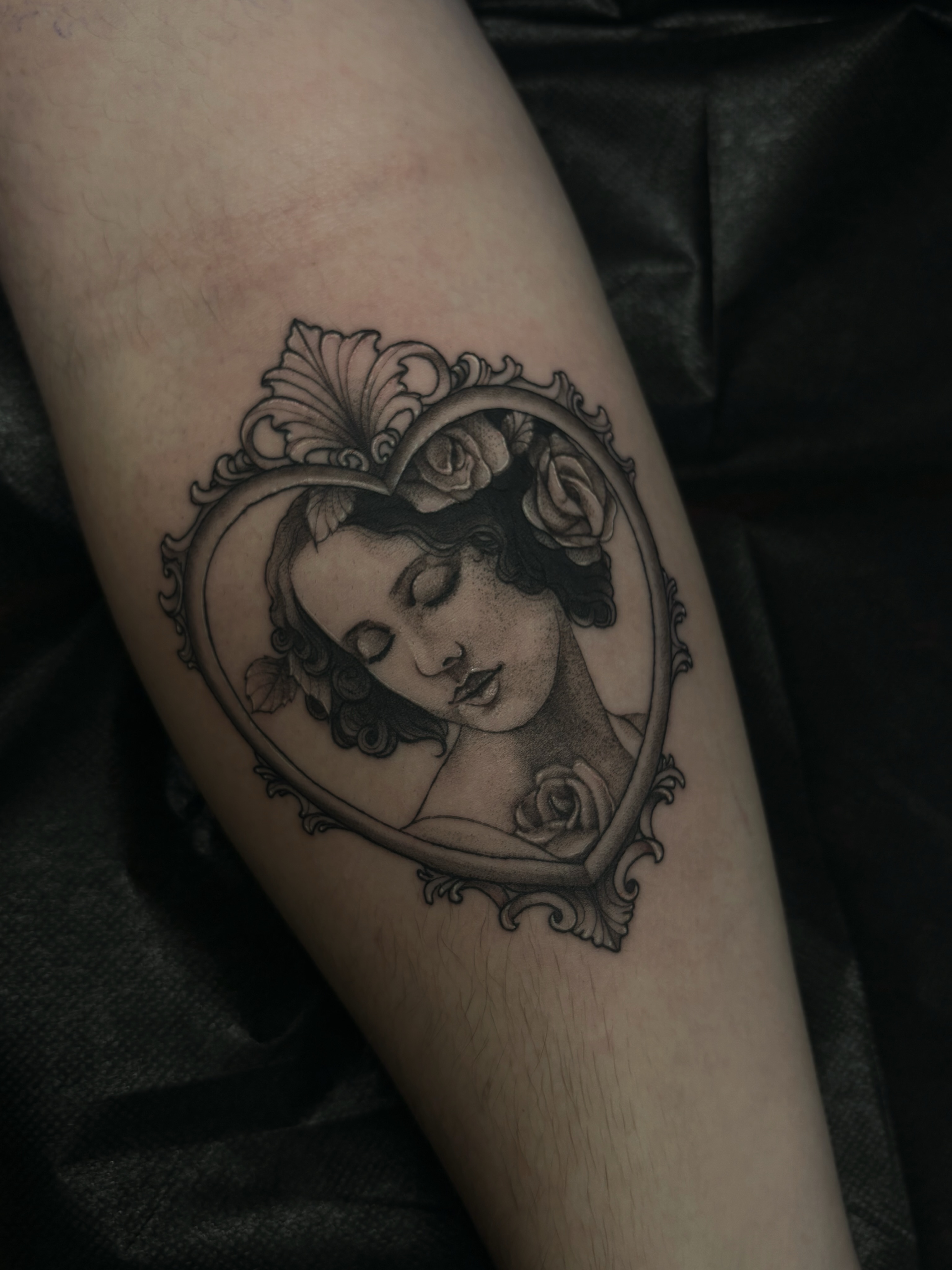 Woman in heart frame realism tattoo on the forearm by Fine Line Tattoo Artist