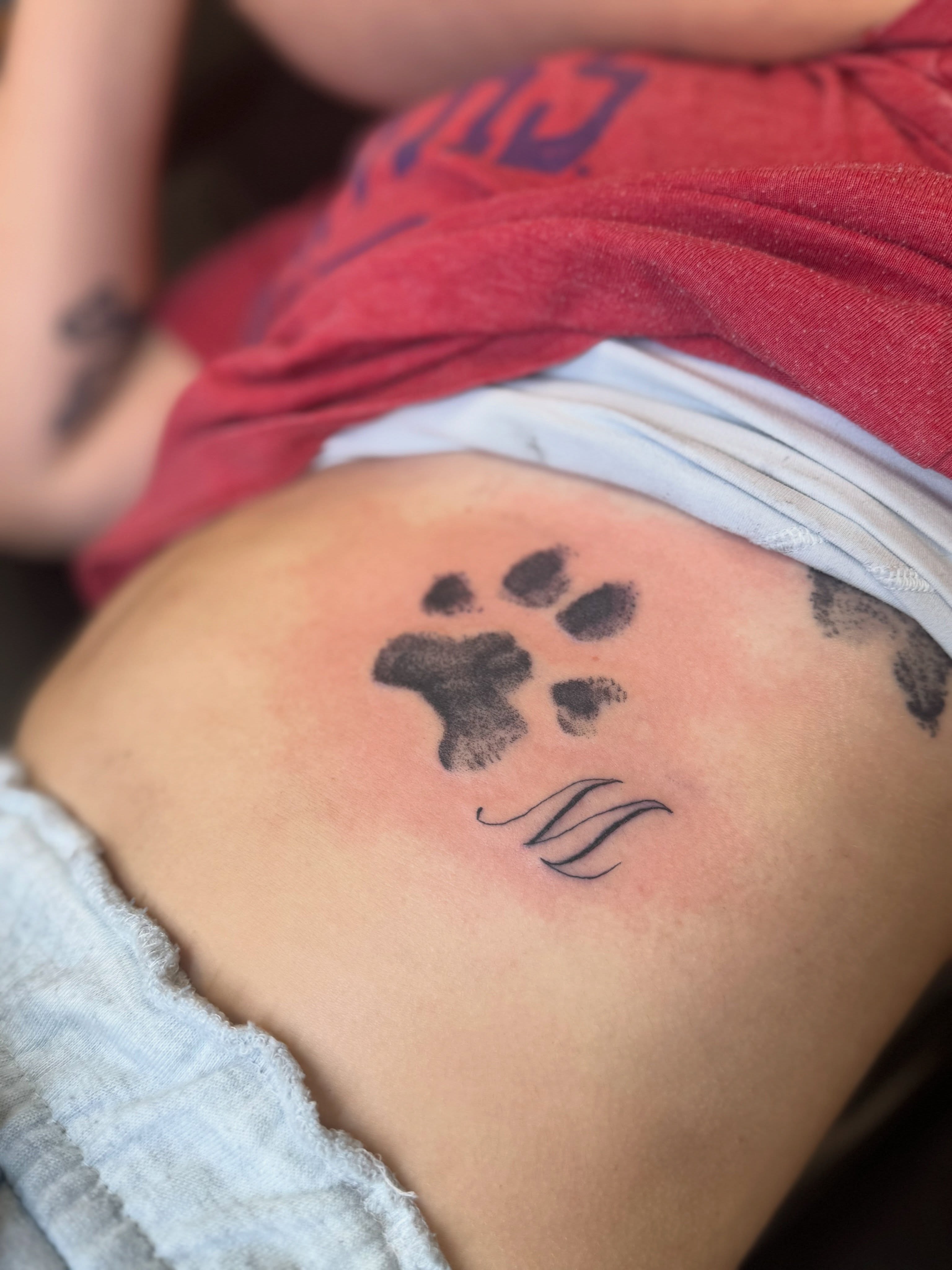 Paw print dotwork tattoo on the thigh by Israel Jacob Woehler