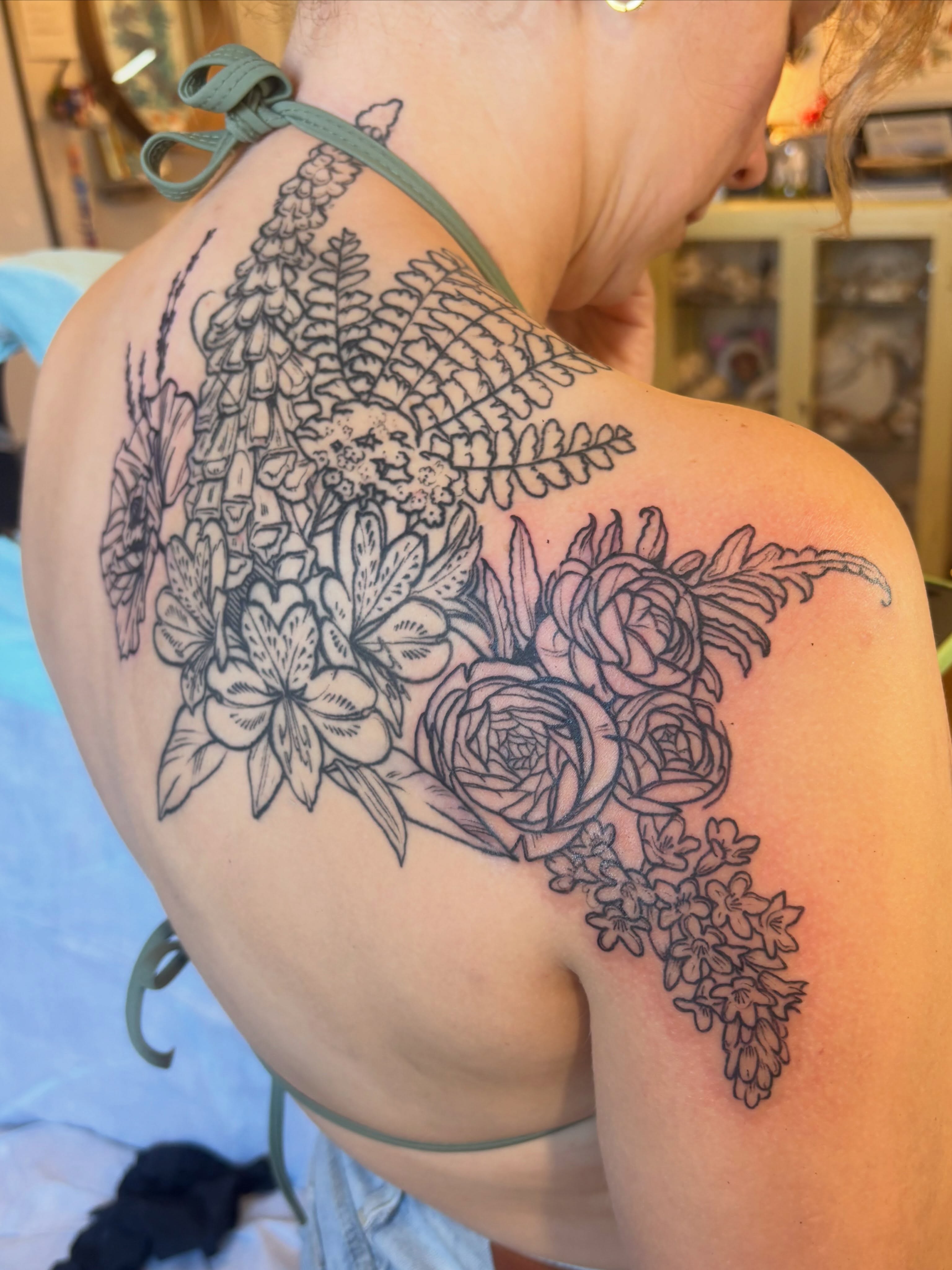 Floral arrangement black and grey tattoo on the shoulder by Zoe Brookes