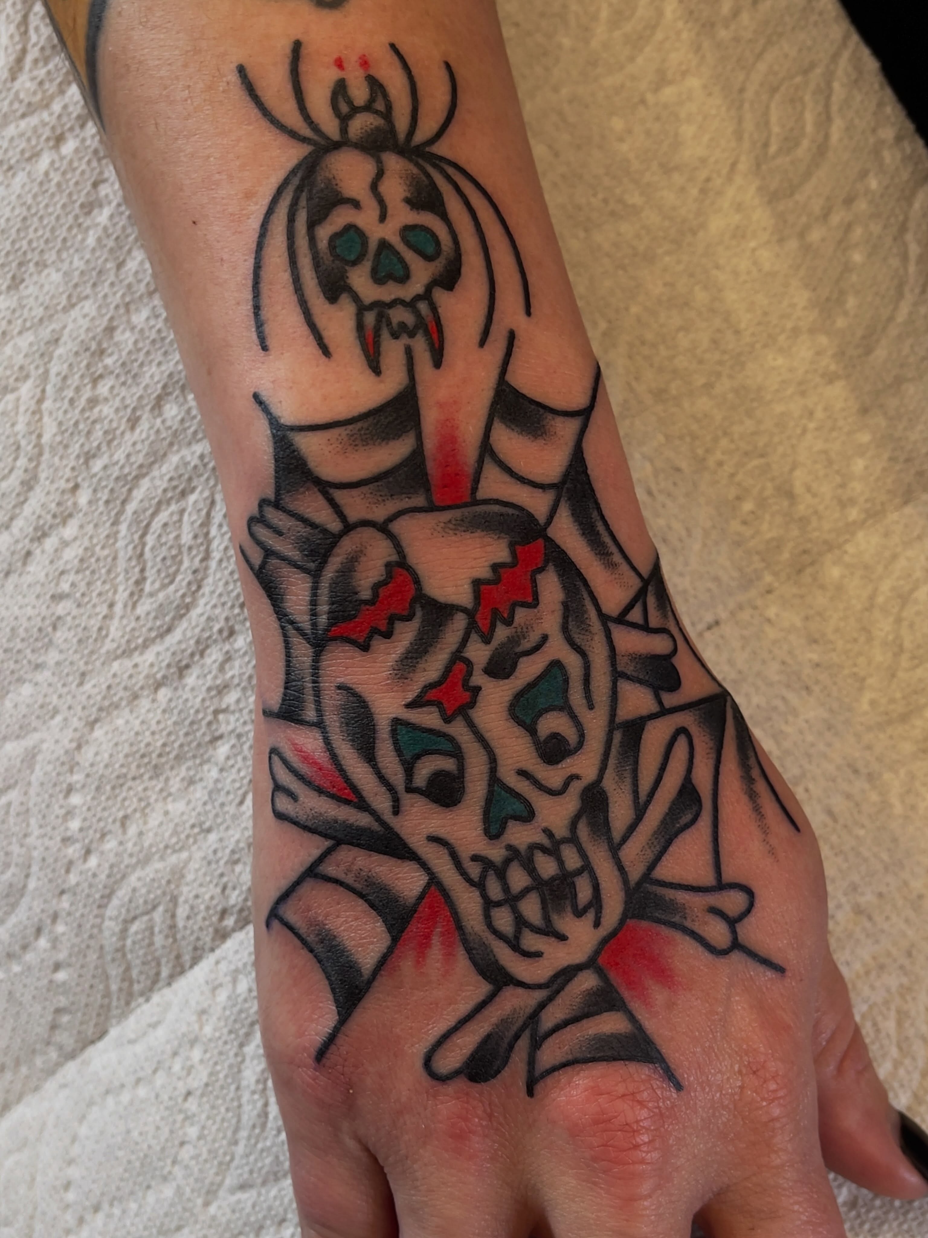 Skulls and bats American traditional tattoo on the hand by Spencer Reisbeck