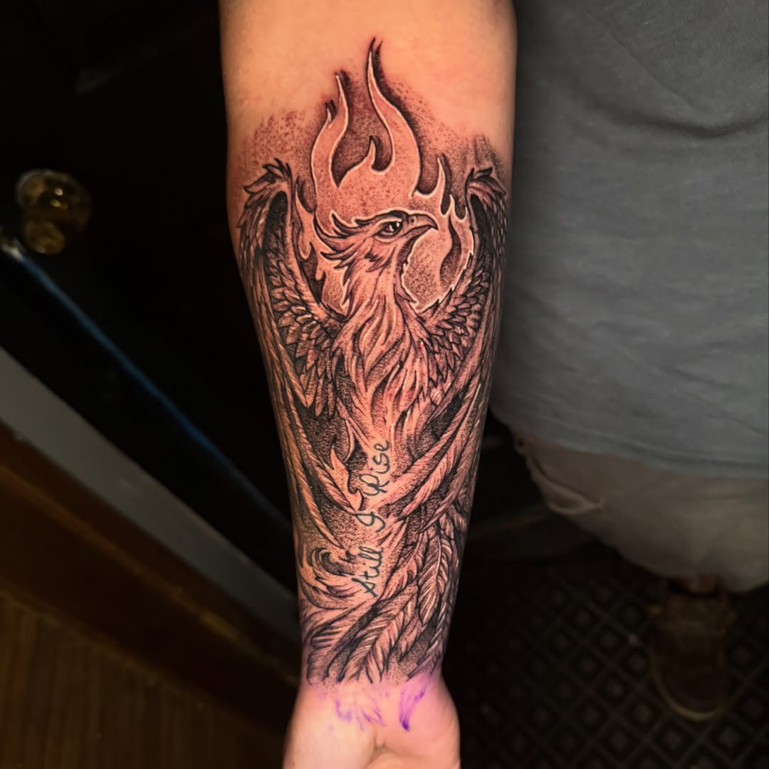 Phoenix black and grey tattoo on the forearm by Alex Wheelock