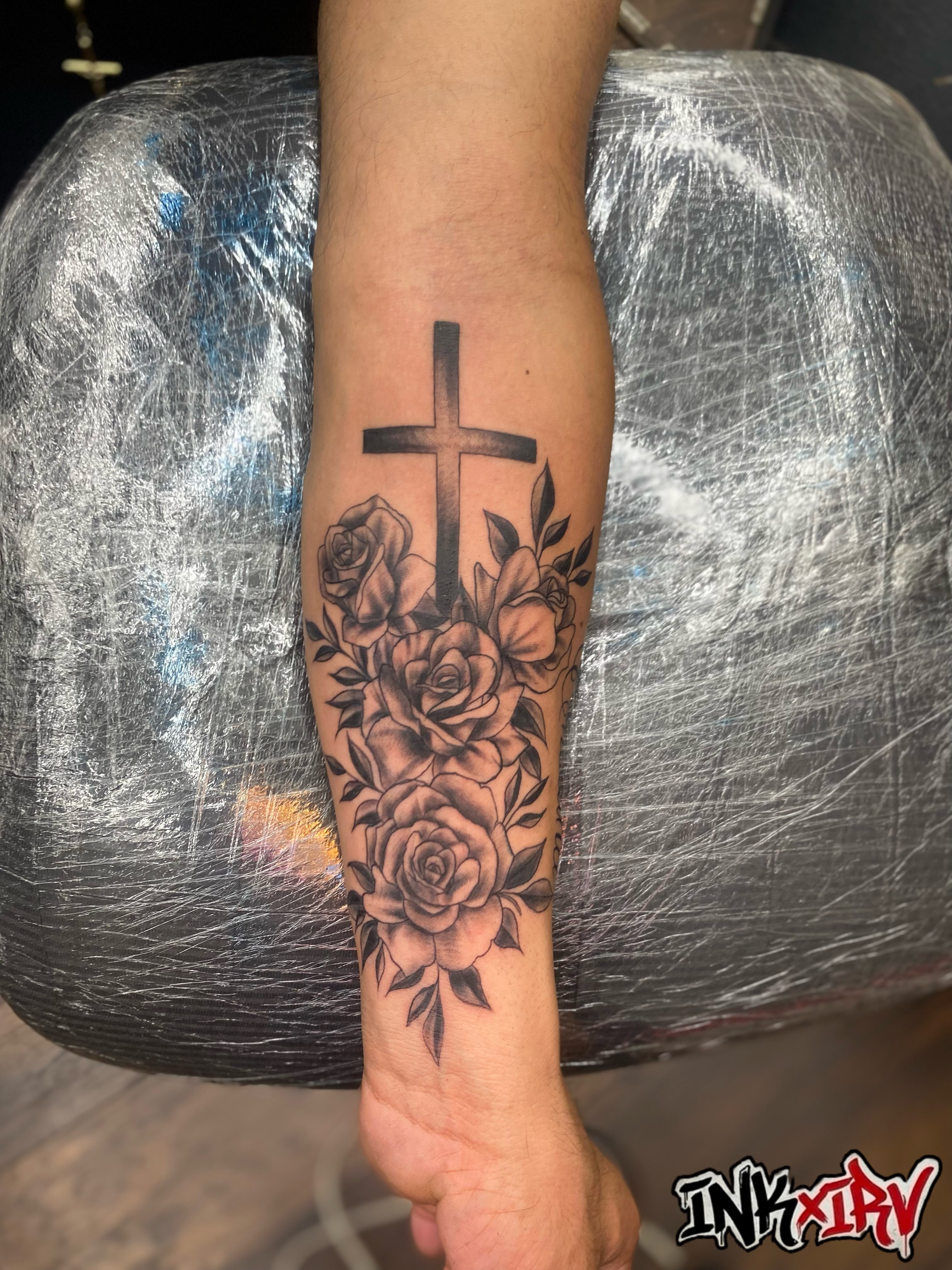 Cross with roses black and grey tattoo on the forearm by Irving Guzman