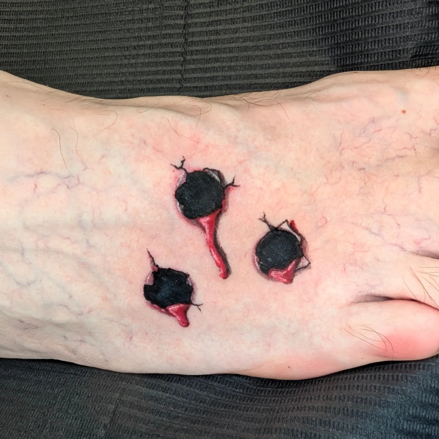 Bullet holes realism tattoo on the foot by Gina Carlson